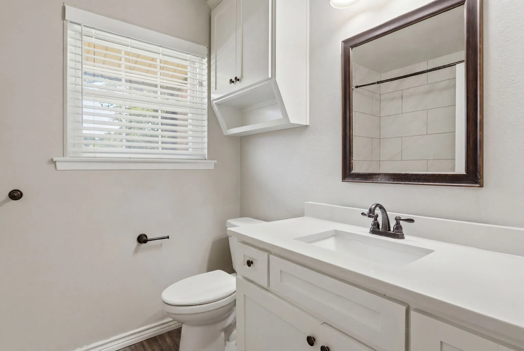 Guest Bathroom vanity featuring white cabinetry, a single basin sink, and a dark bronze faucet