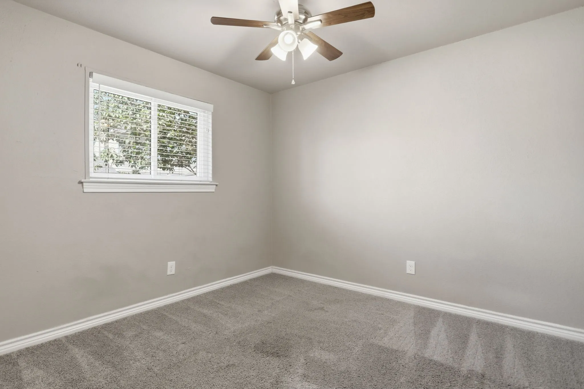 Room featuring neutral wall paint, gray carpet flooring, and white baseboards