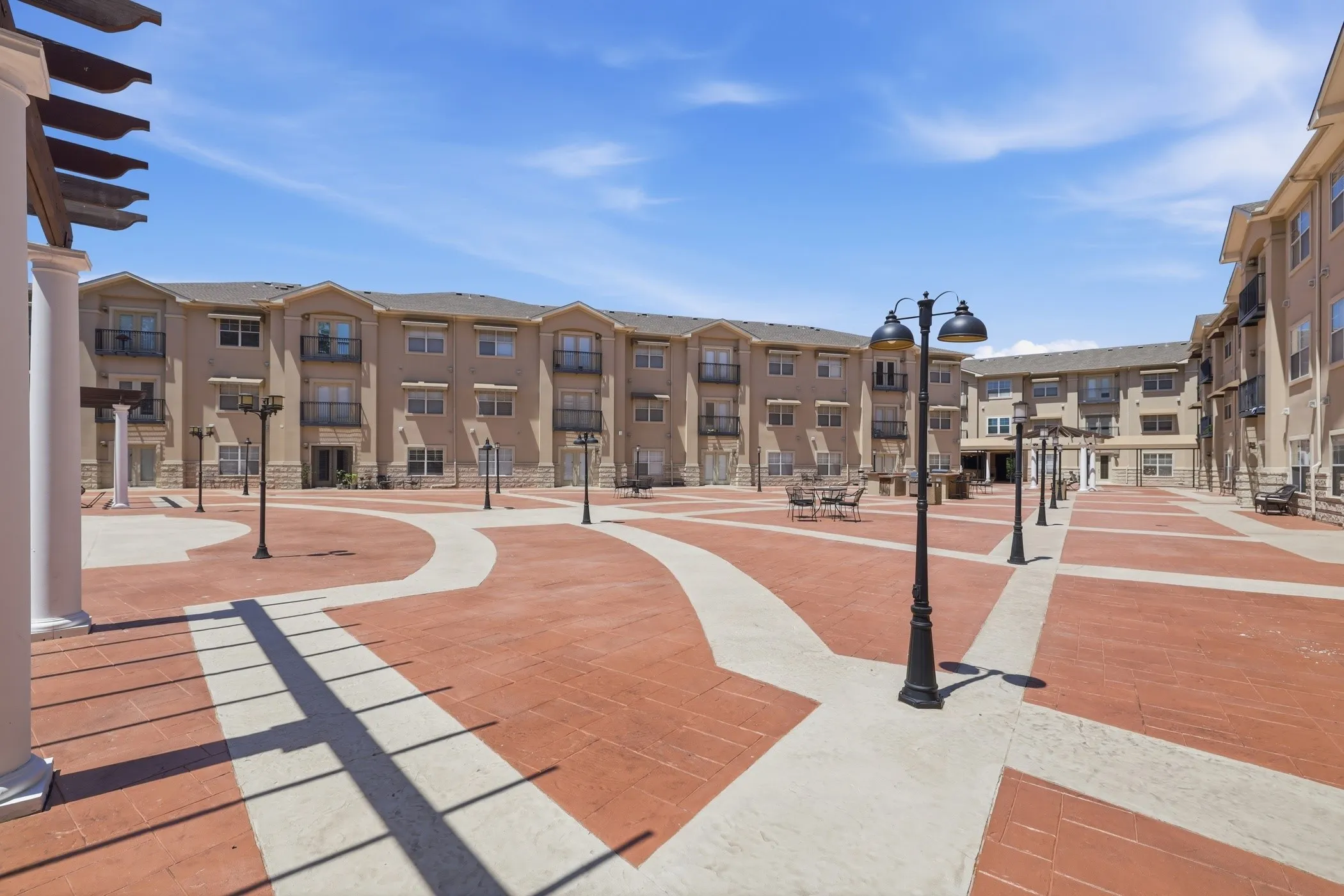 Expansive central courtyard featuring patterned paver and concrete pathways