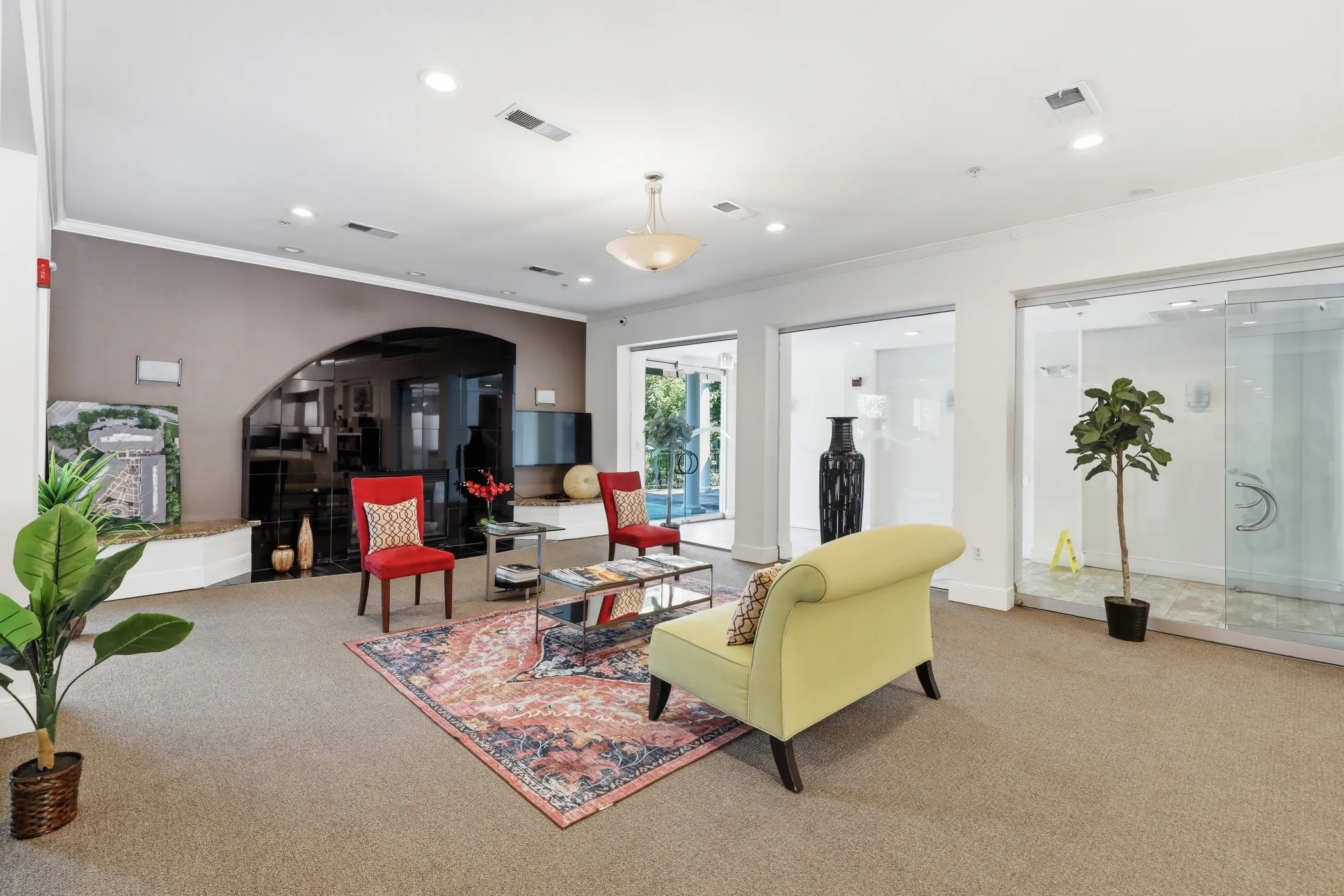 Spacious common area featuring recessed lighting, carpeted flooring, and a decorative arched wall element