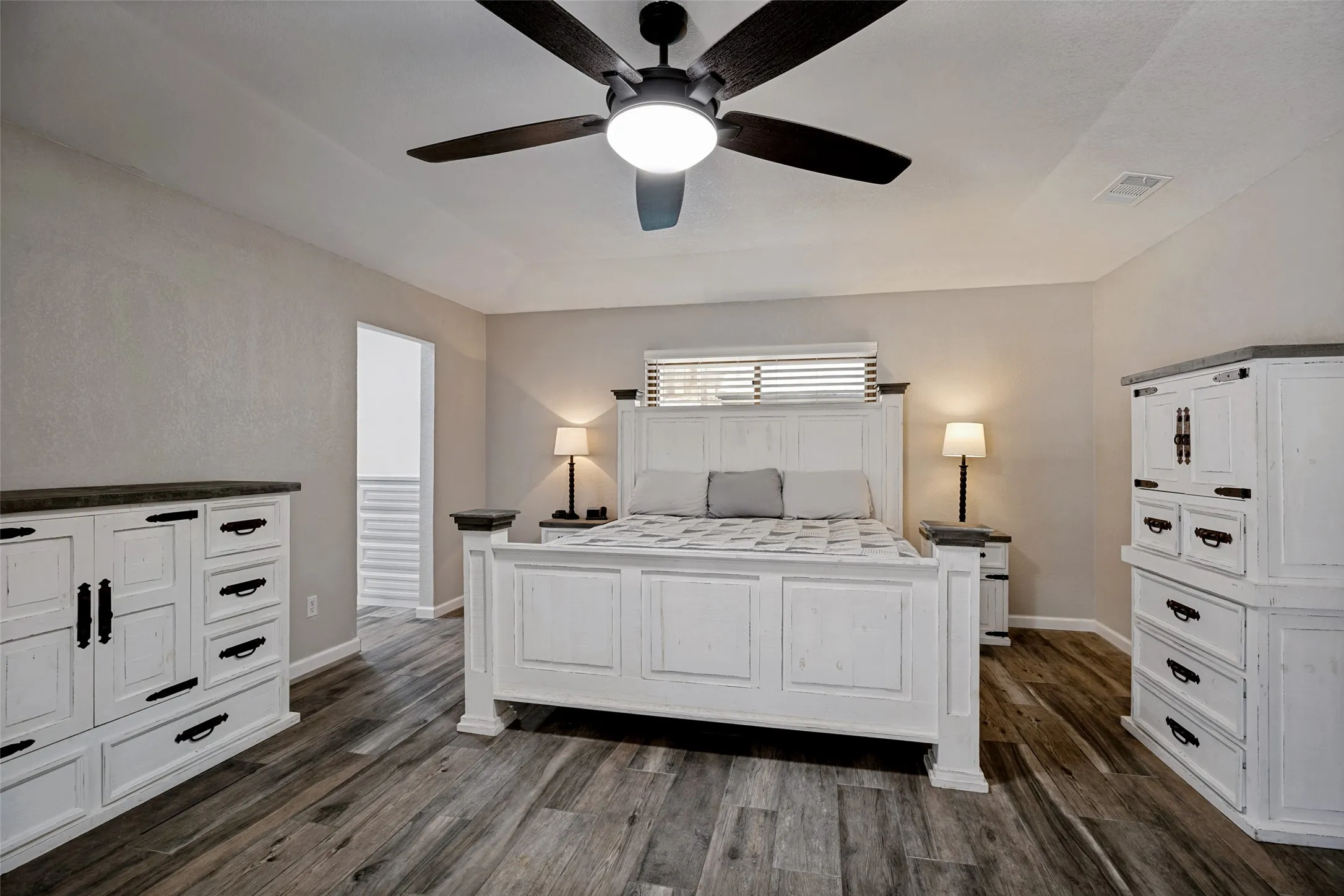 Spacious room featuring porcelain ceramic wood-finish flooring, a contemporary ceiling fan with integrated lighting, and neutral wall tones