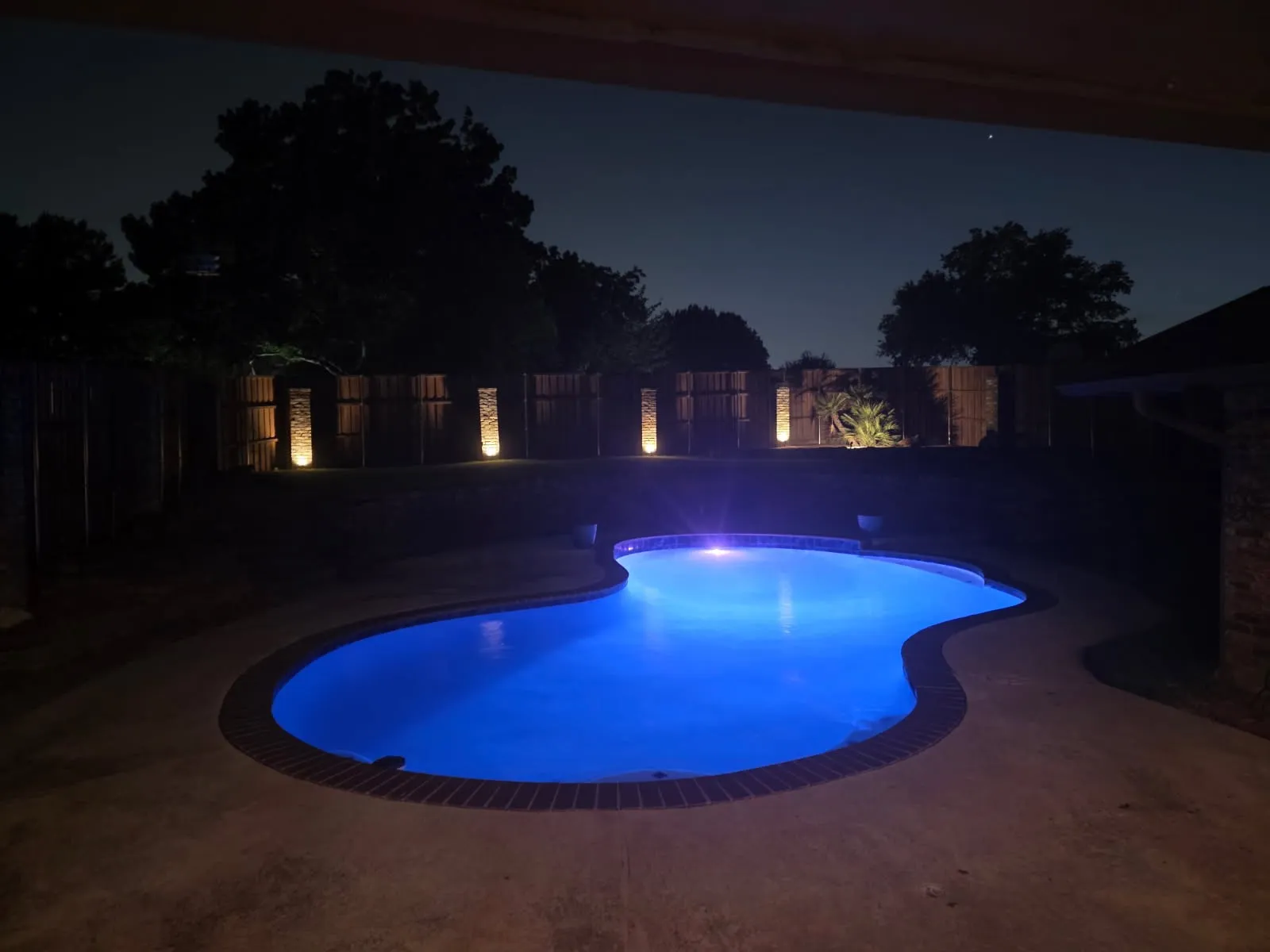 Freeform swimming pool with blue interior lighting