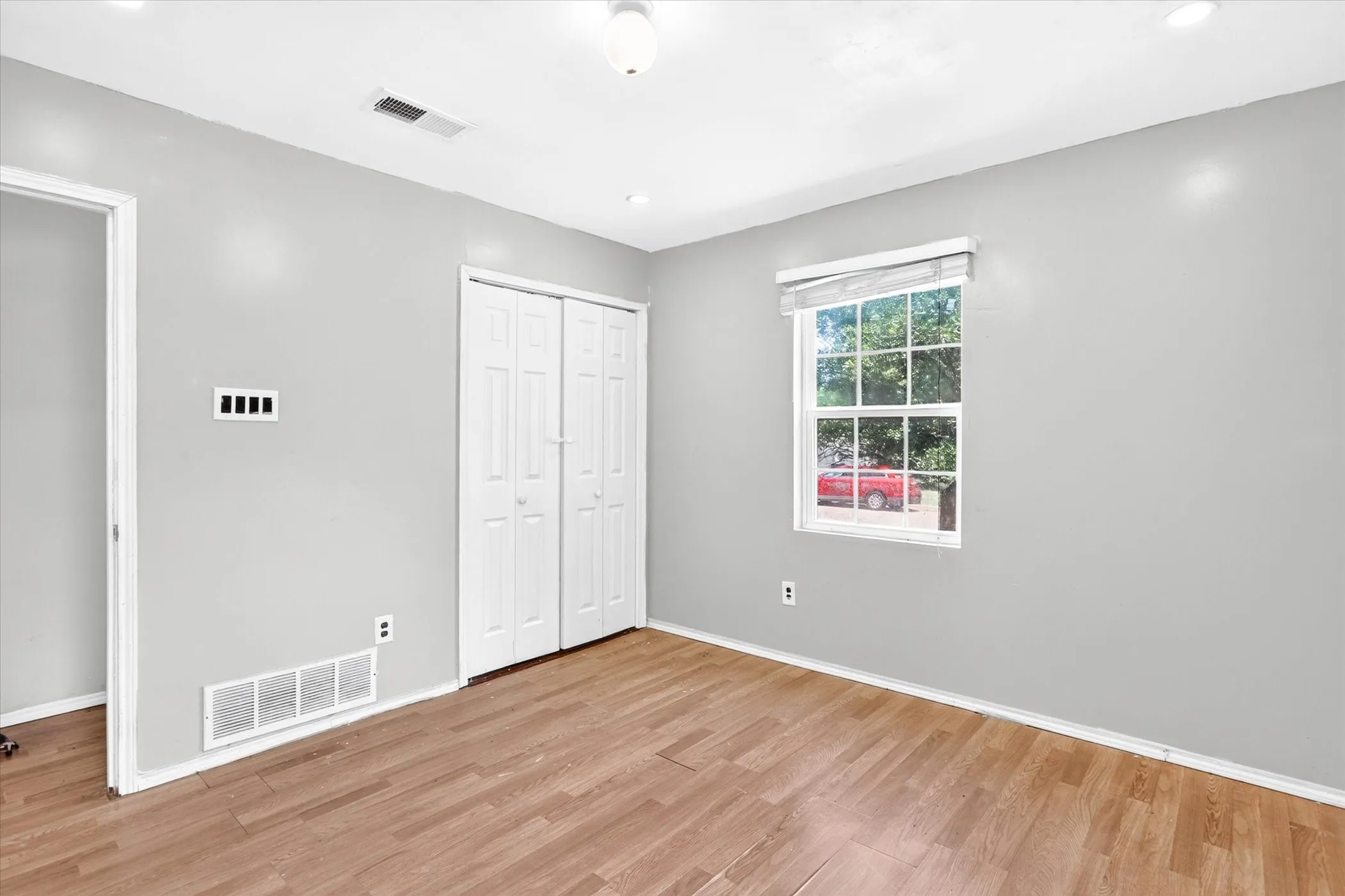 Bedroom featuring a double-panel closet, a window with natural light, and light gray walls