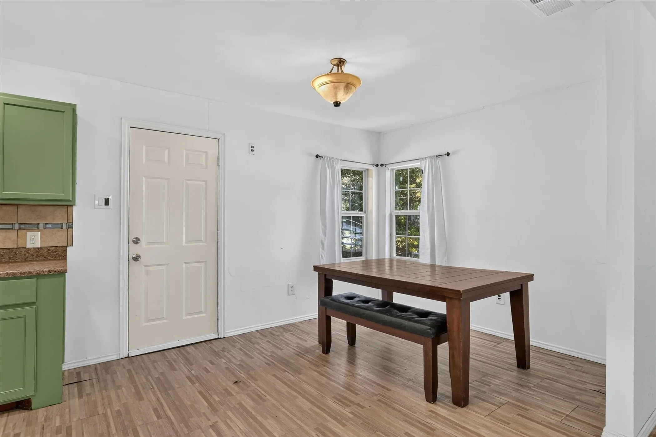 Dining area with door leading to backyard.