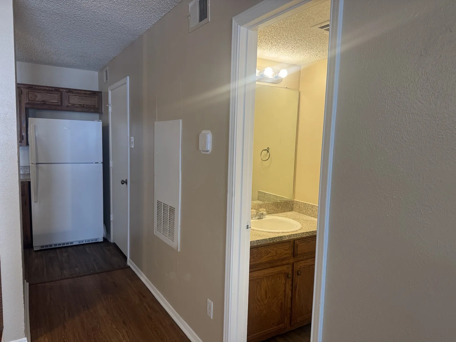 Kitchen and bathroom featuring wood-finish flooring