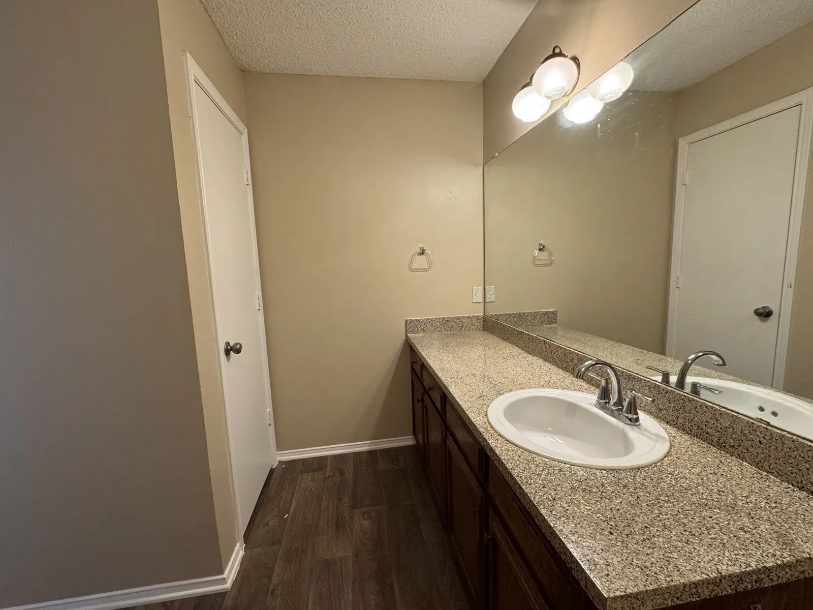 Bathroom vanity featuring a speckled countertop, integrated sink, and brushed nickel fixtures