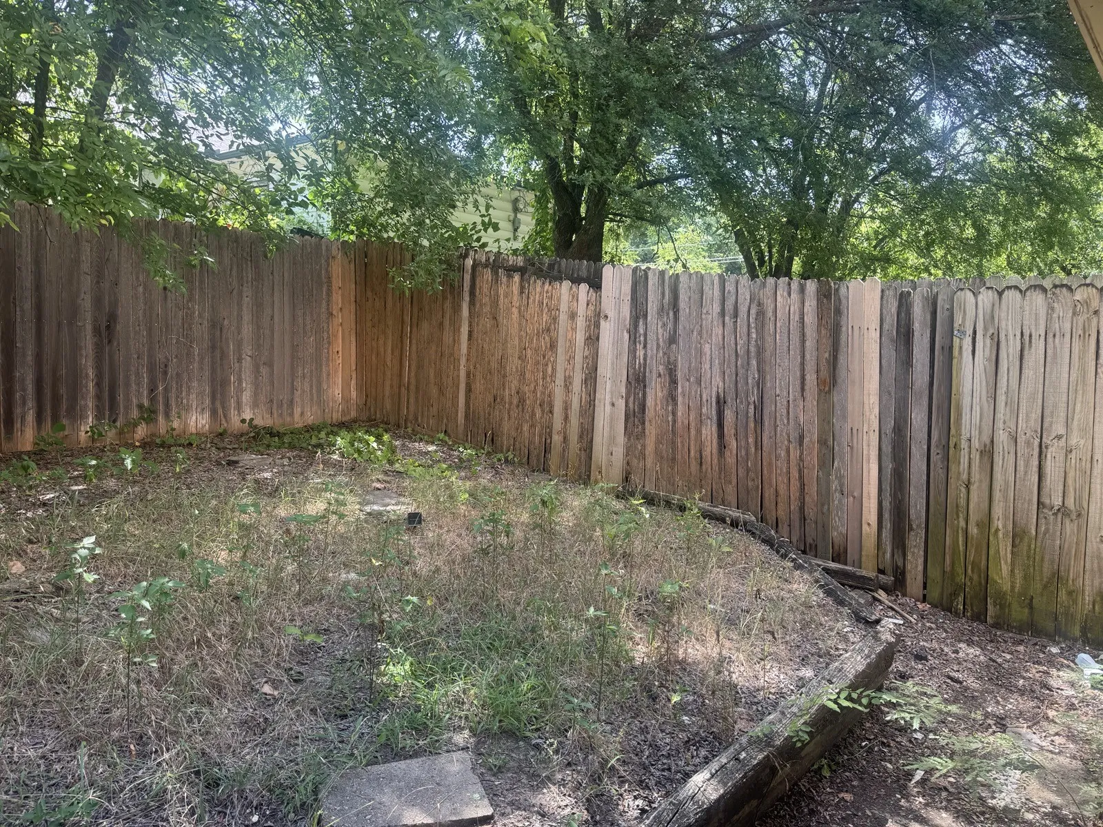 Fenced backyard featuring natural wood fencing