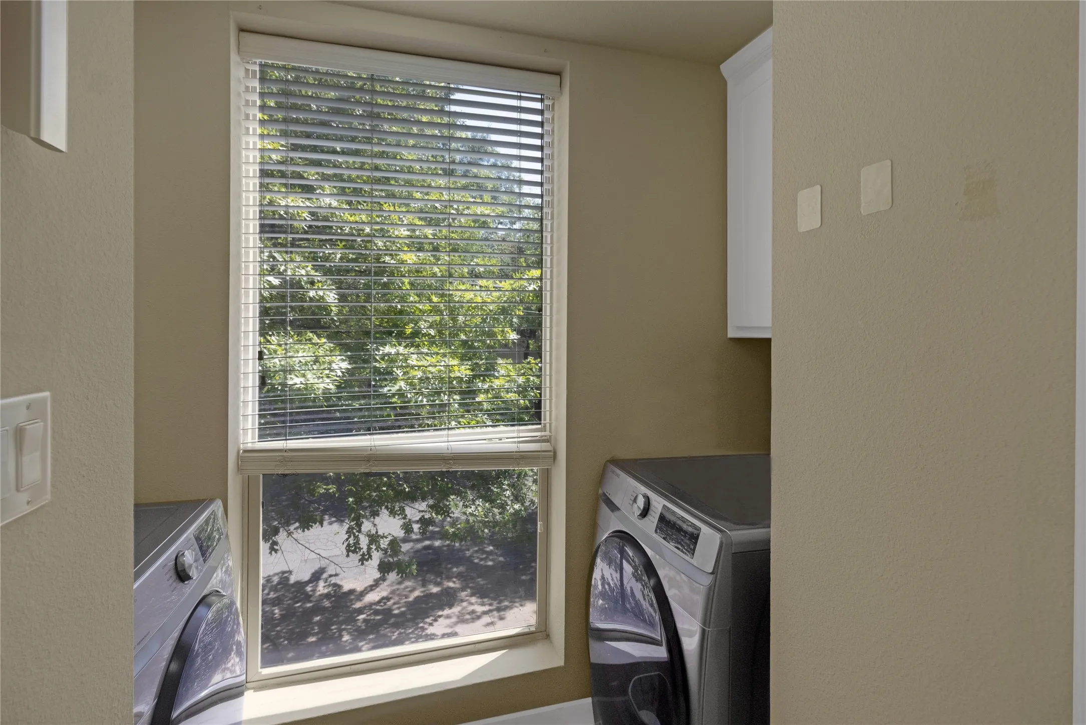 Window with horizontal blinds and surrounding neutral-toned walls