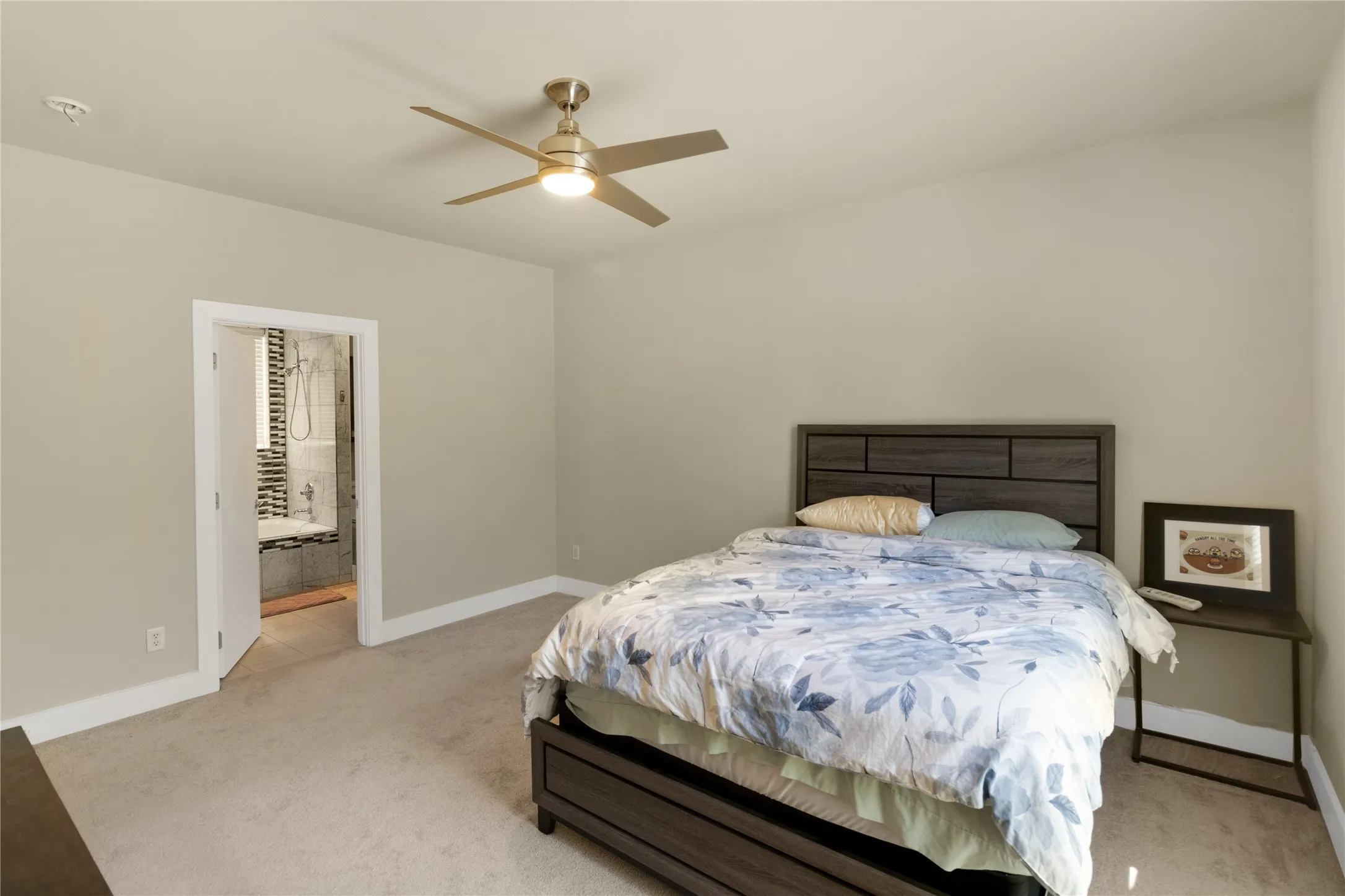 Bright room with light-toned walls and plush carpet flooring and ensuite bath