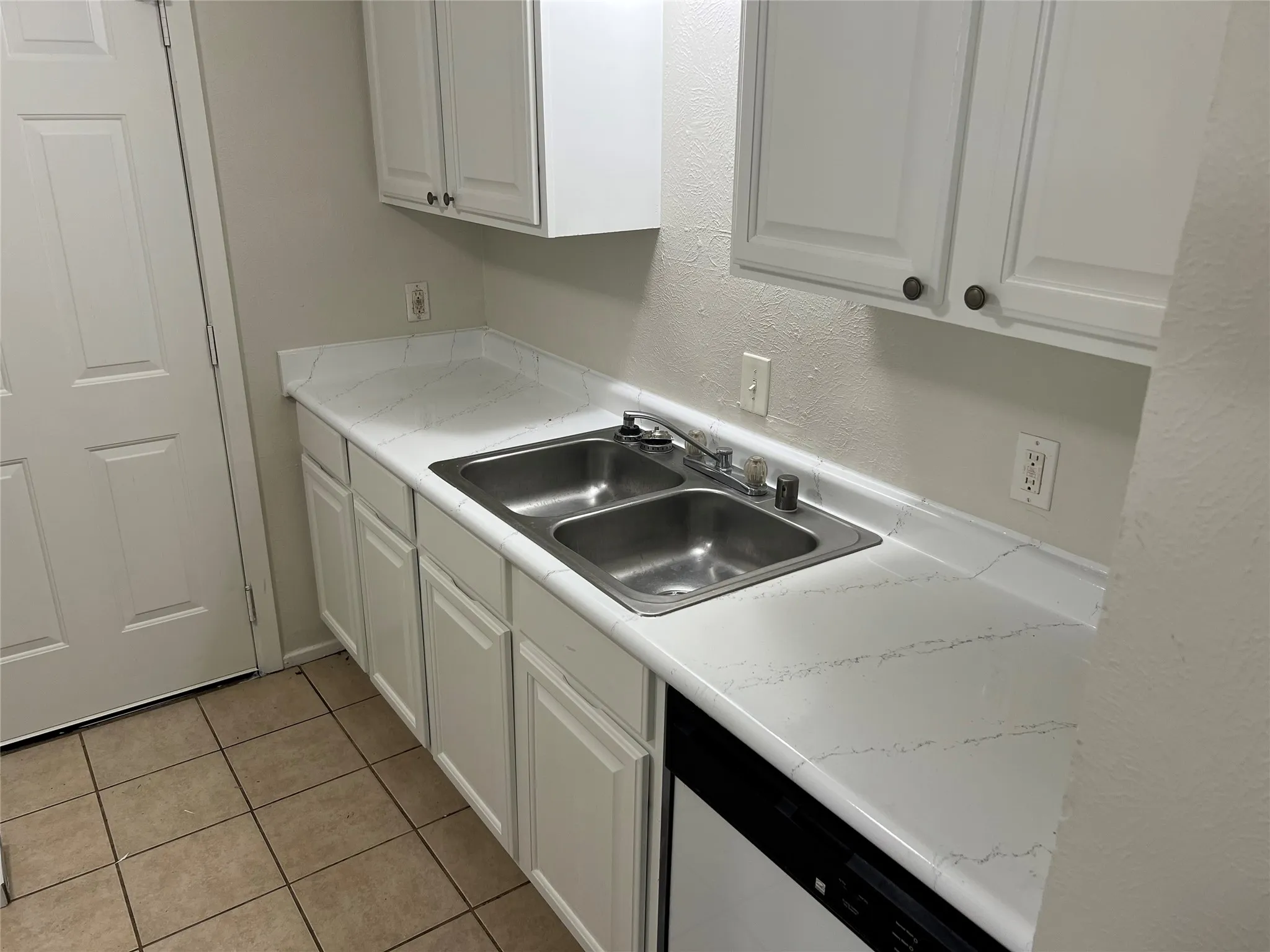 Kitchen workspace featuring a double basin stainless steel sink with a chrome faucet