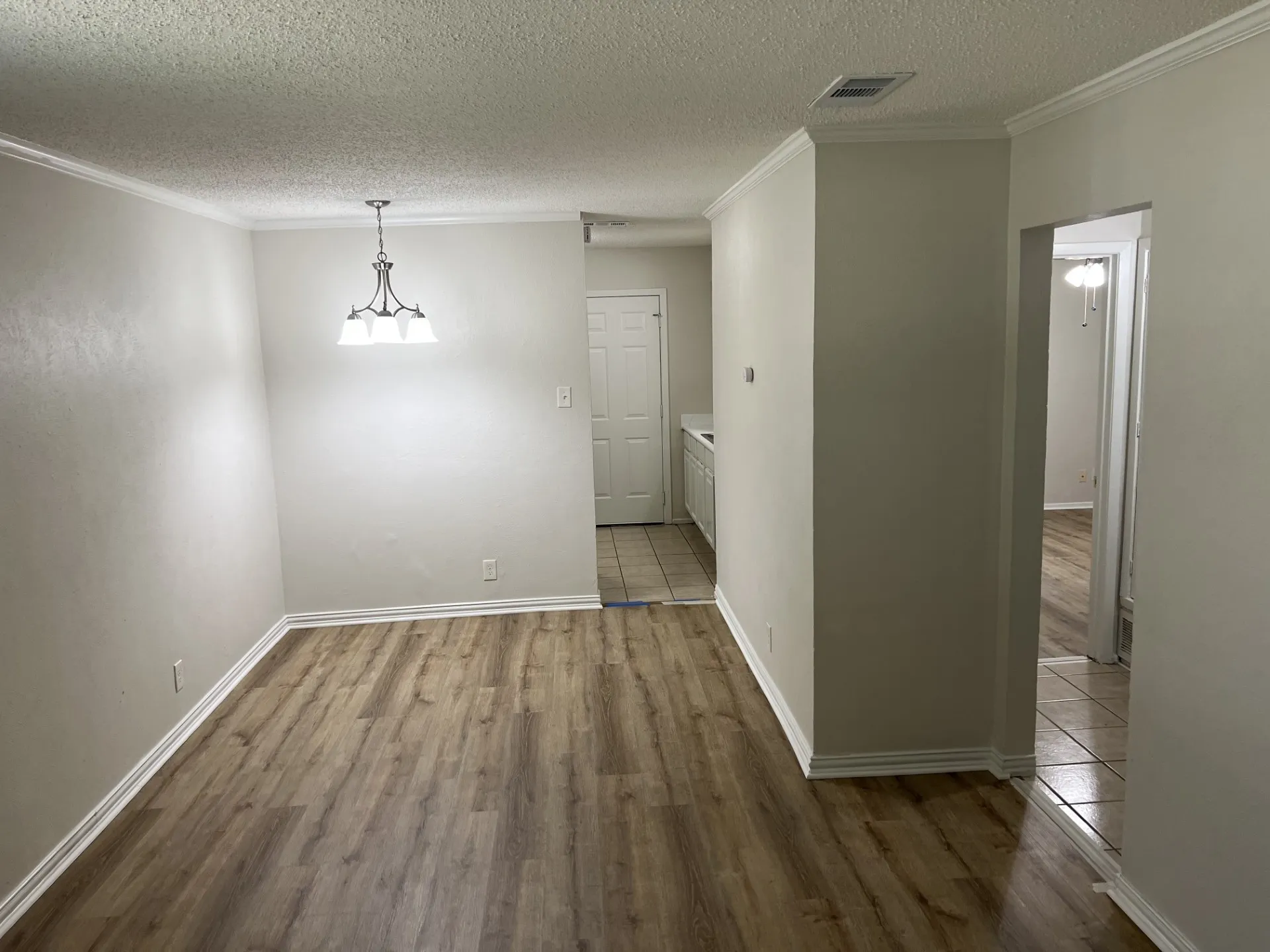 Light-toned walls with crown molding and wood-finish flooring