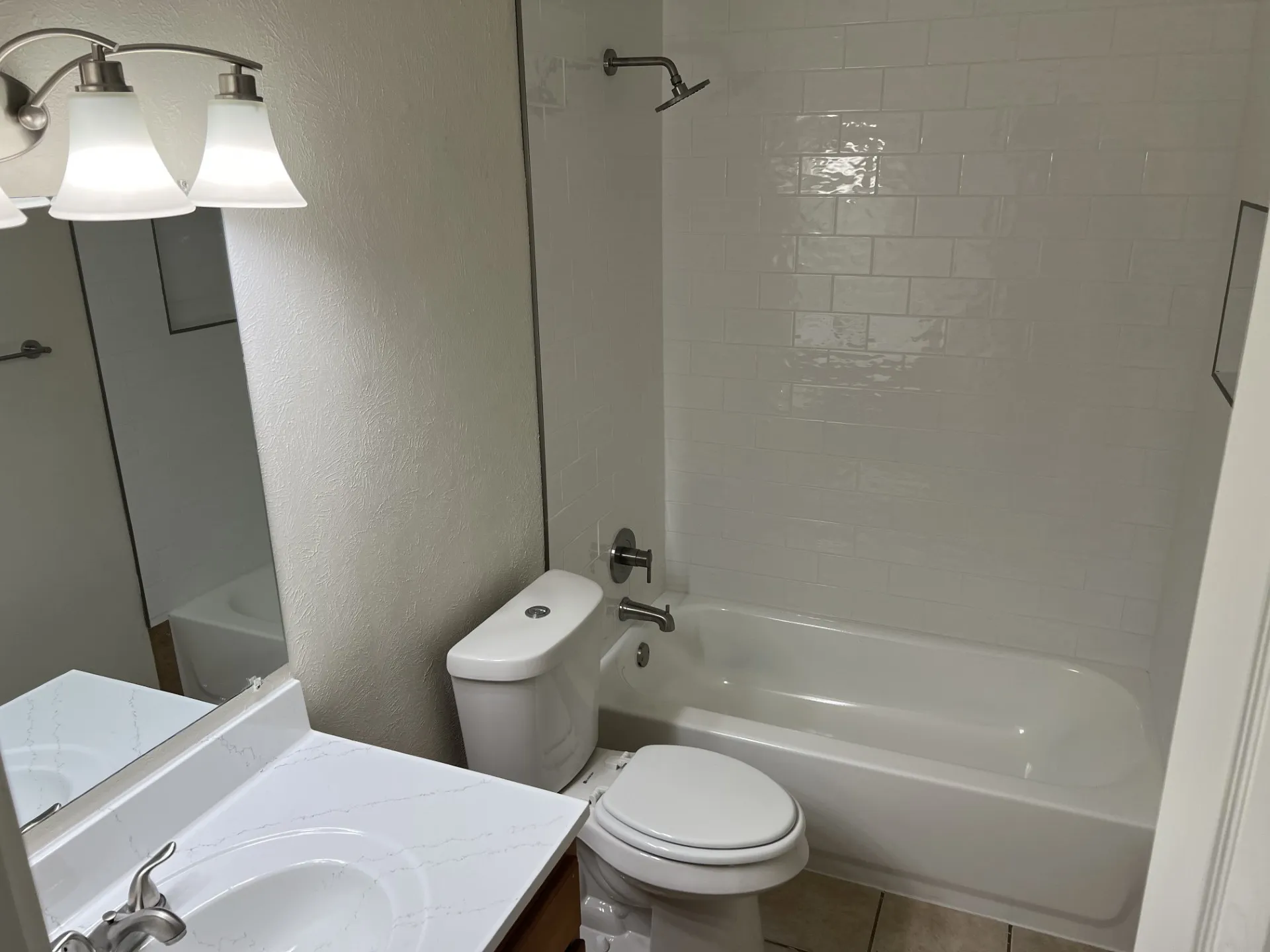 Bathroom featuring a combination bathtub and shower with white subway tile surround