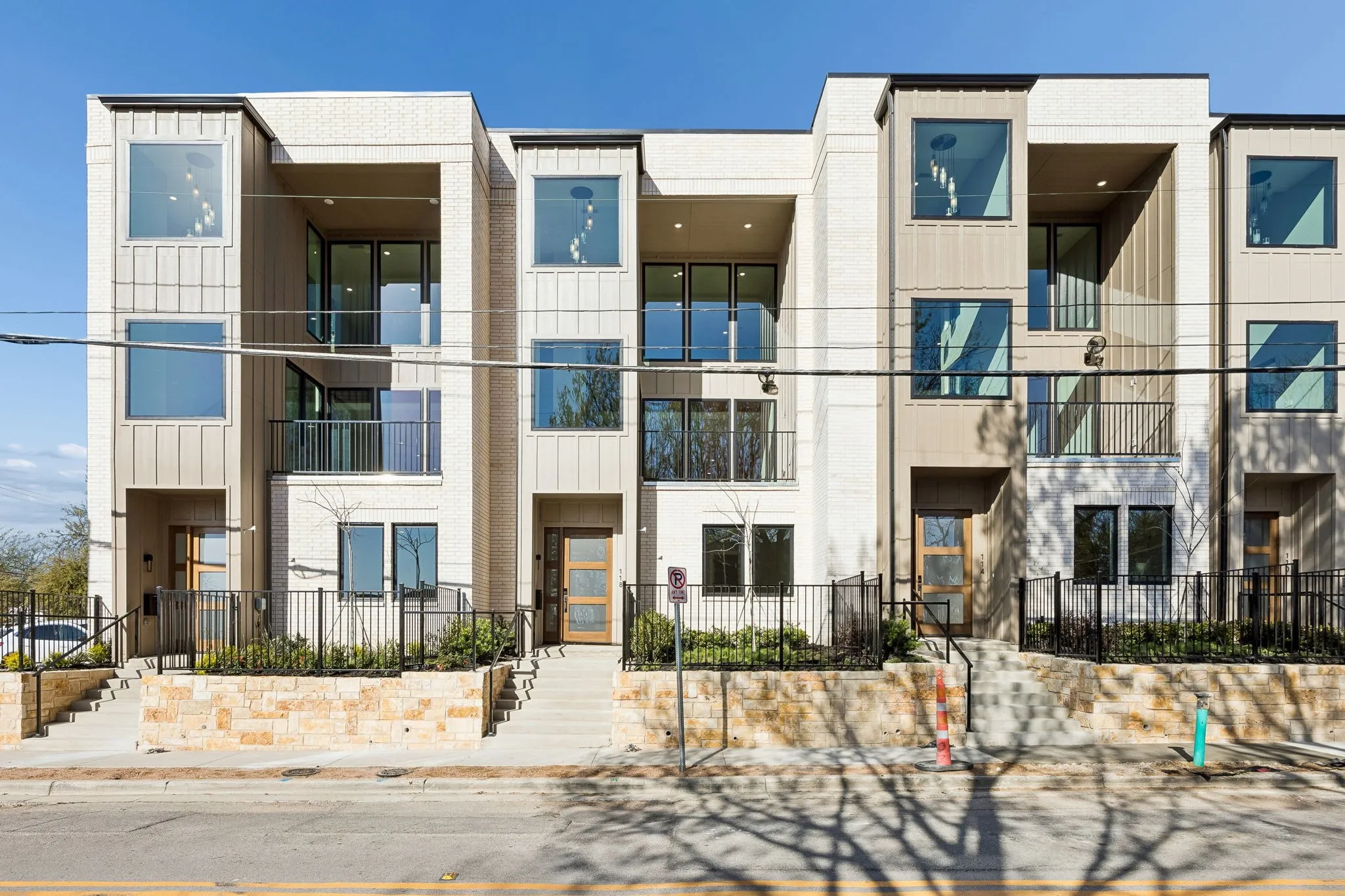 Contemporary townhome exterior featuring light-colored brick and vertical paneling accents