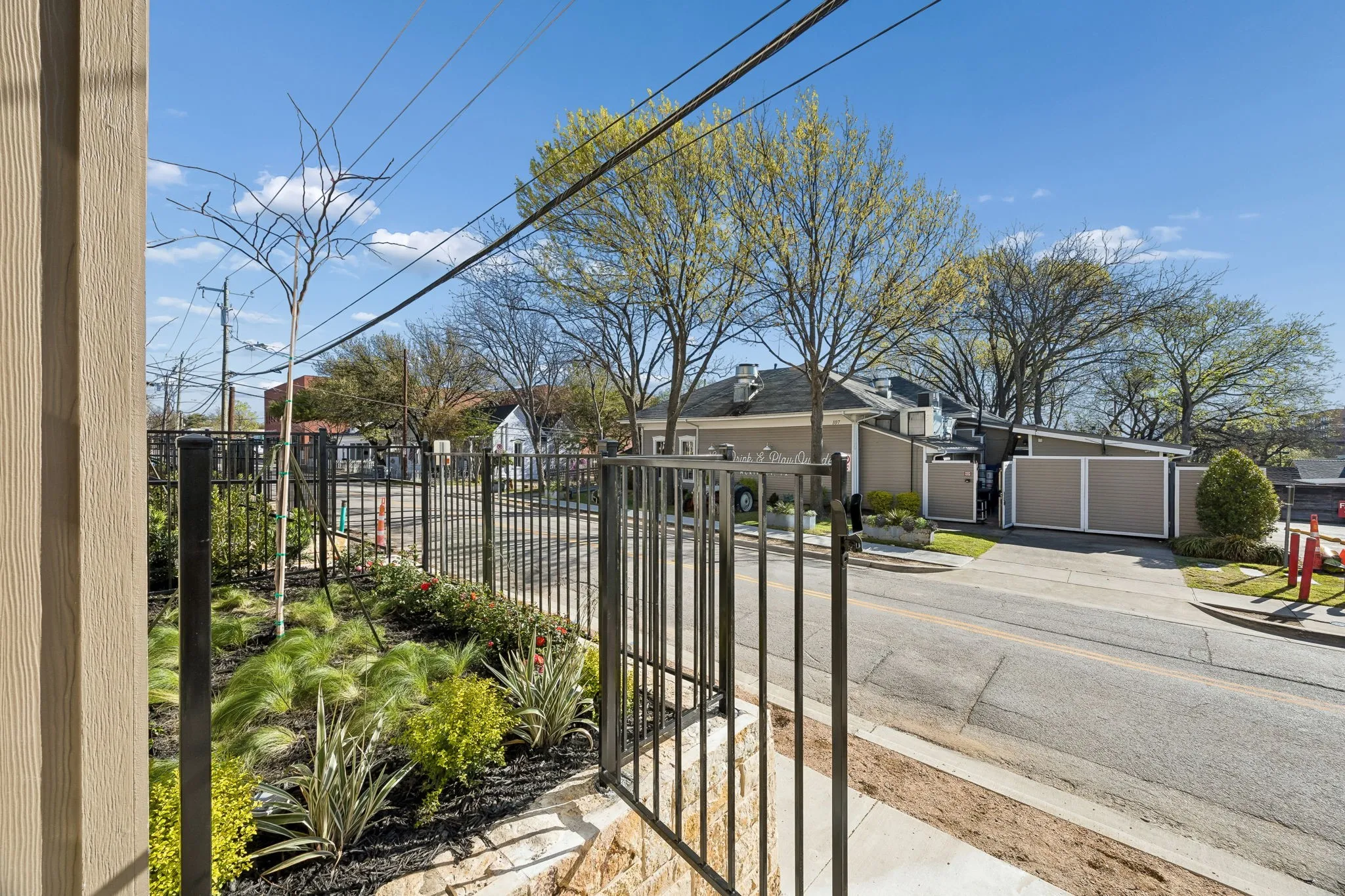 Wrought iron fencing enclosing a landscaped planting area with a stone base