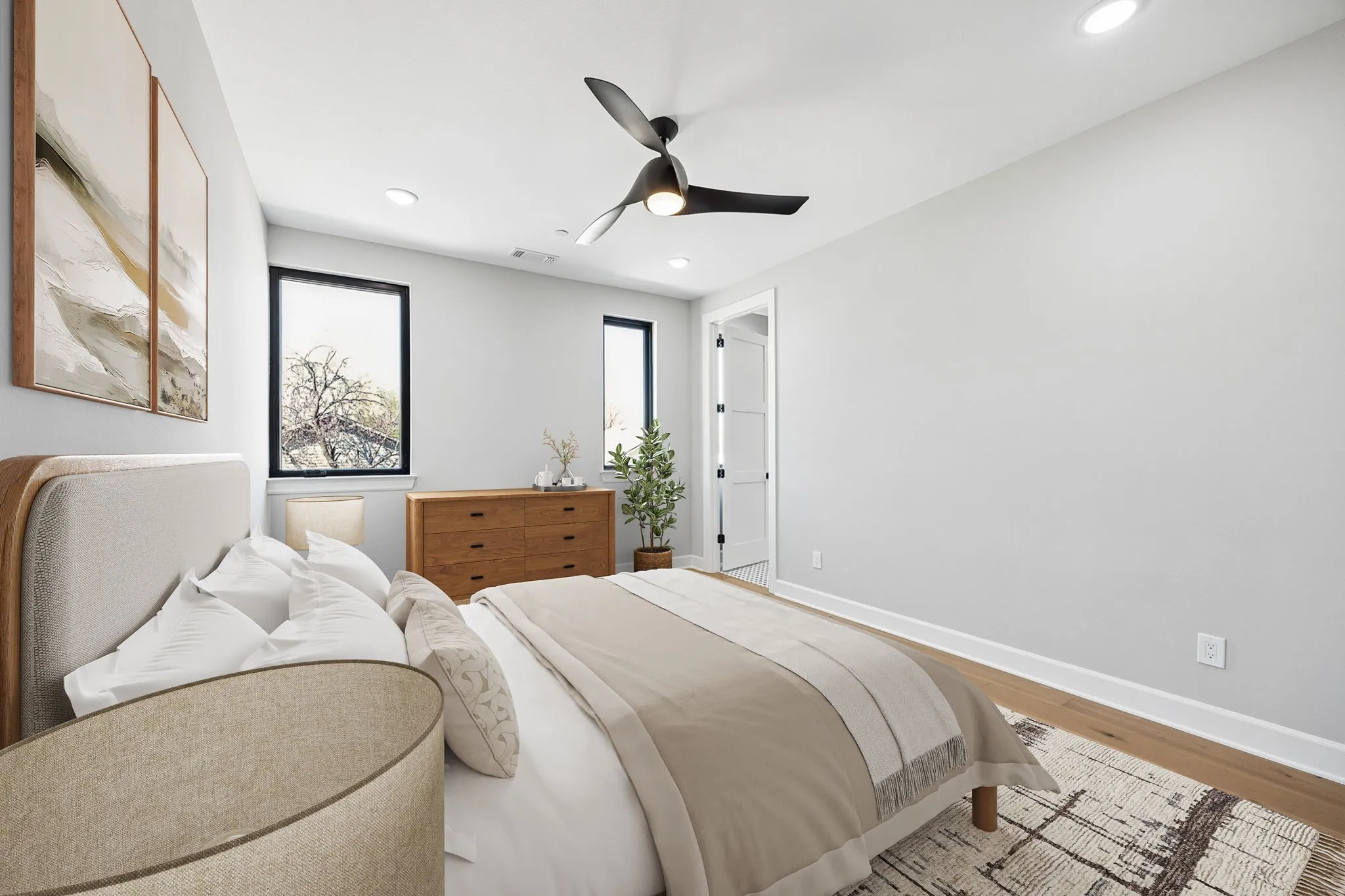 Recessed ceiling lighting, wood-finish flooring, a modern black ceiling fan, and two windows with black frames