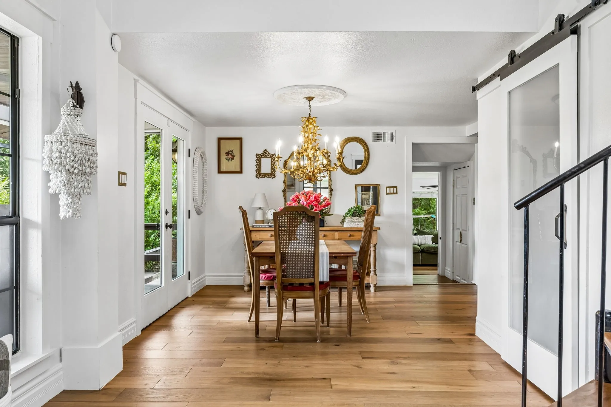 Large double doors and a window frame the dining area, allowing you to gather for family dinners paired with peaceful, picturesque views of the property.