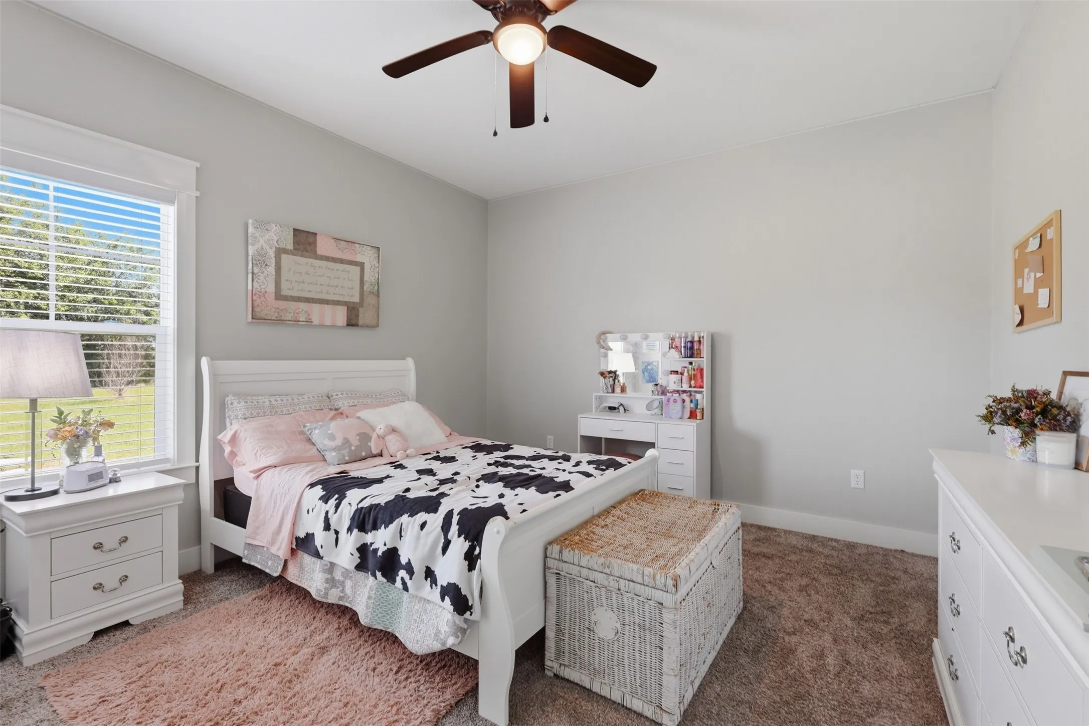 Carpeted interior space featuring a window with integrated blinds, a ceiling fan, and light gray wall paint