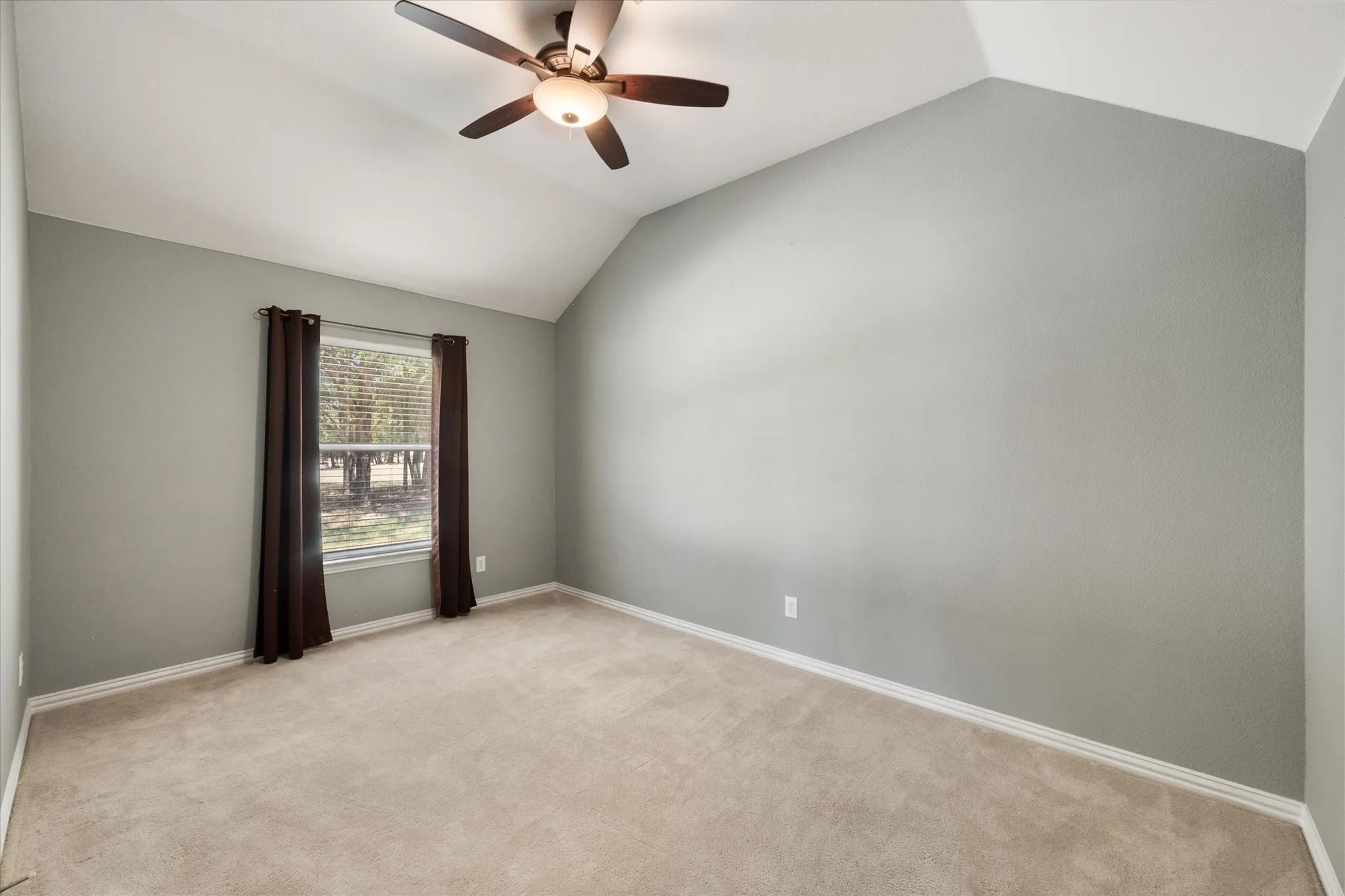 Secondary bedroom offers vaulted ceilings, neutral finishes, and room for guests or family.