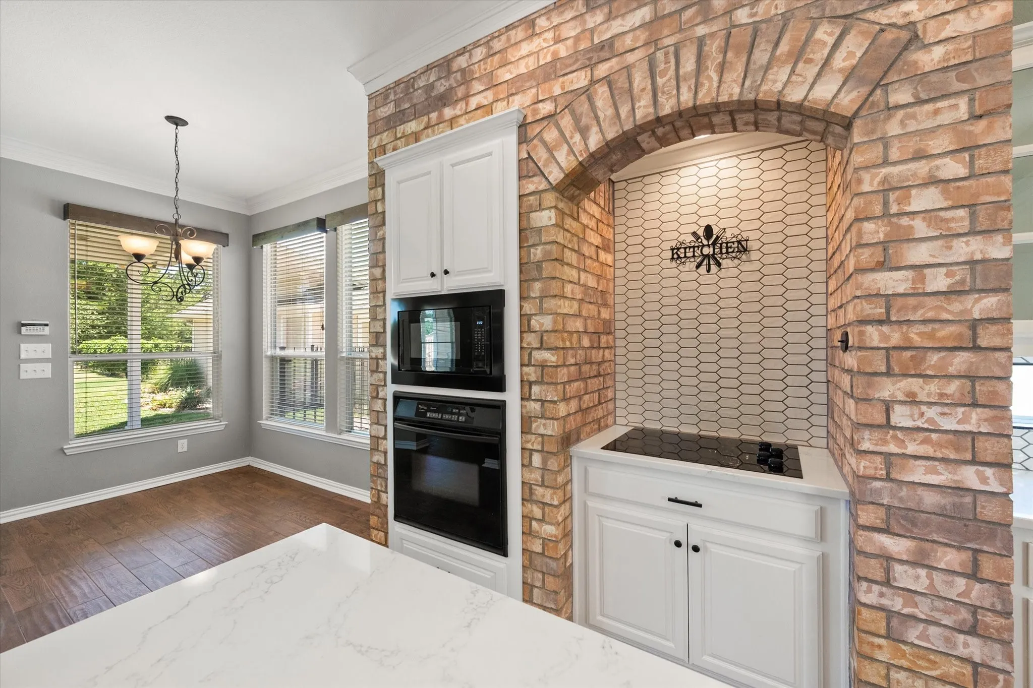 Brick cooktop alcove and built-in oven wall add custom character to this updated Kerens TX kitchen.