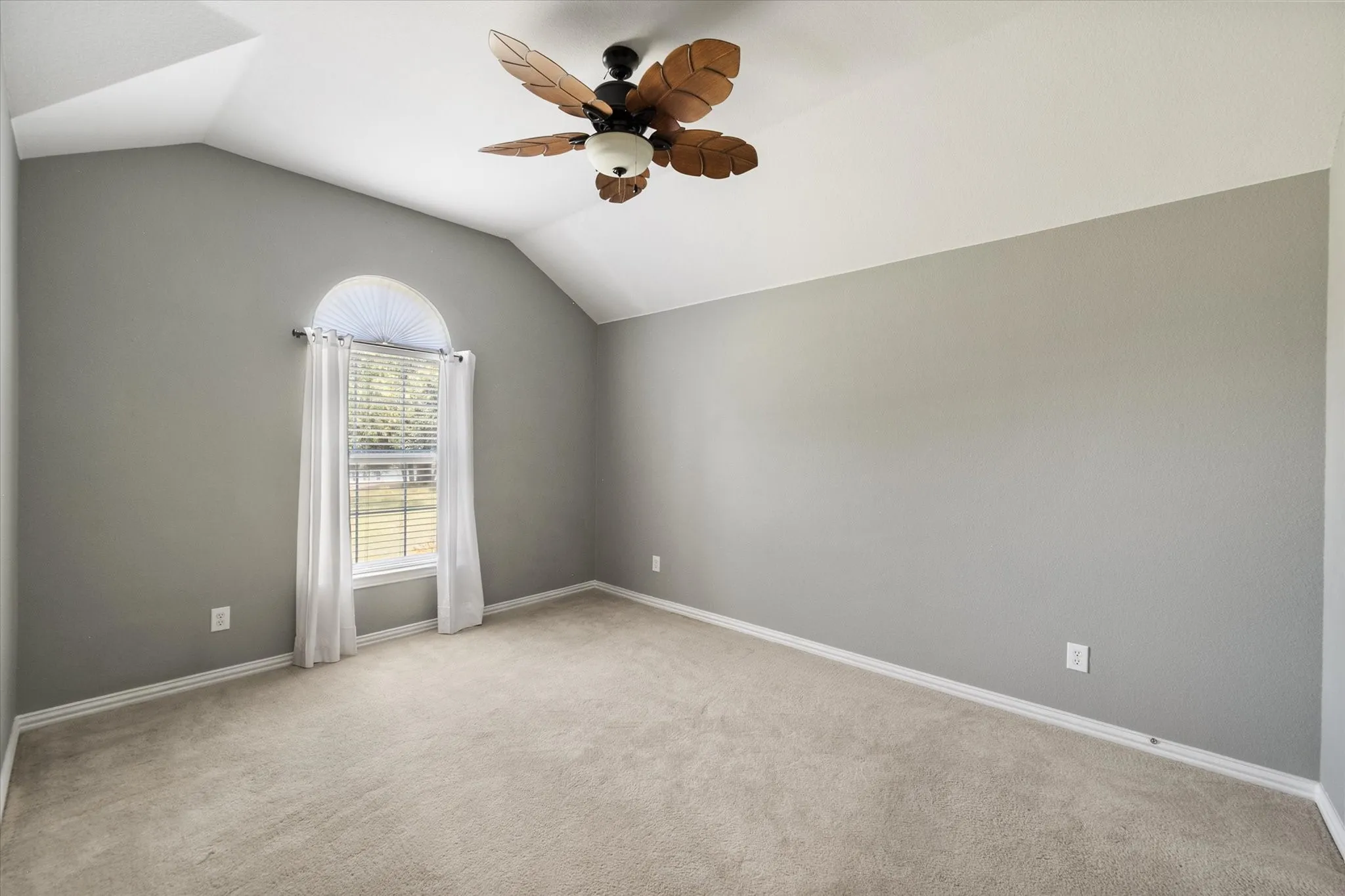 Additional secondary bedroom features a vaulted ceiling, arched window, and flexible layout.