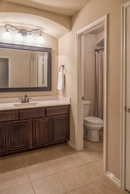 Bathroom vanity featuring a single basin, dark wood cabinetry, and a light-toned countertop