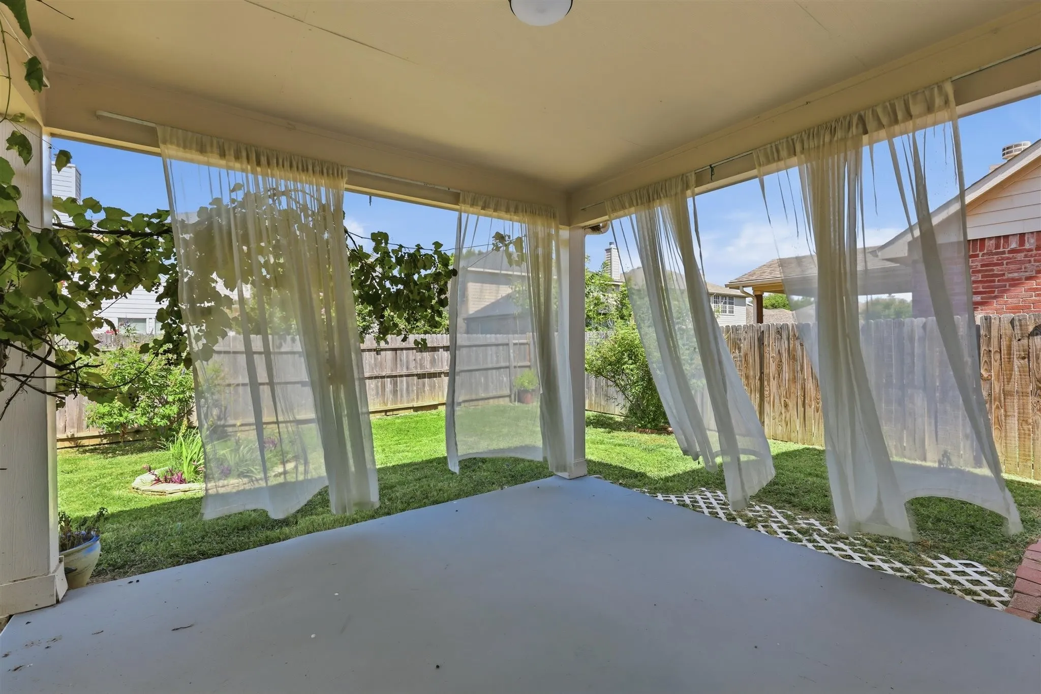 Covered patio featuring a concrete floor and perimeter privacy curtains