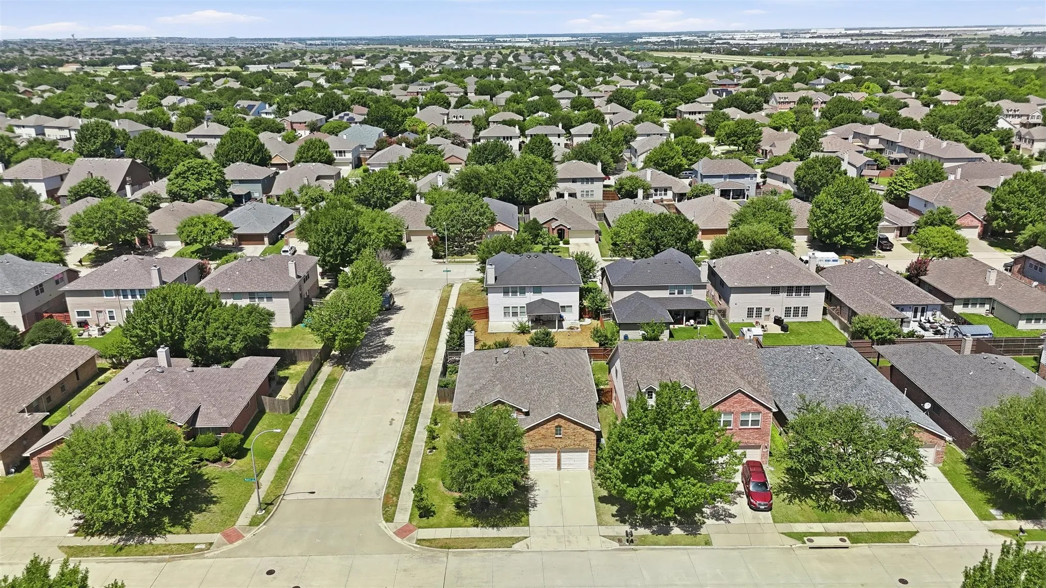 Sprawling residential community featuring a variety of single-family homes with mature trees and paved streets