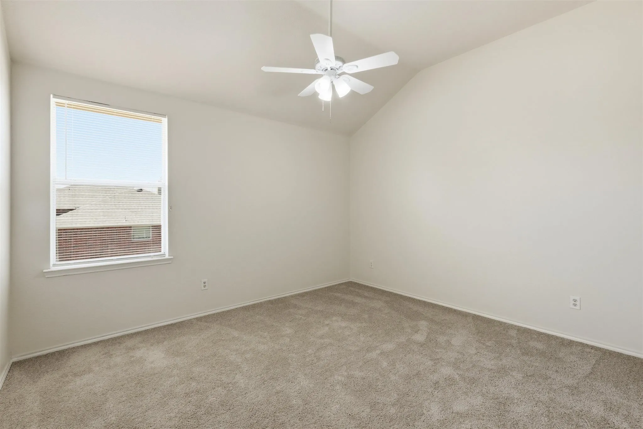 Bedroom featuring a vaulted ceiling, neutral wall paint, and light-toned carpet flooring