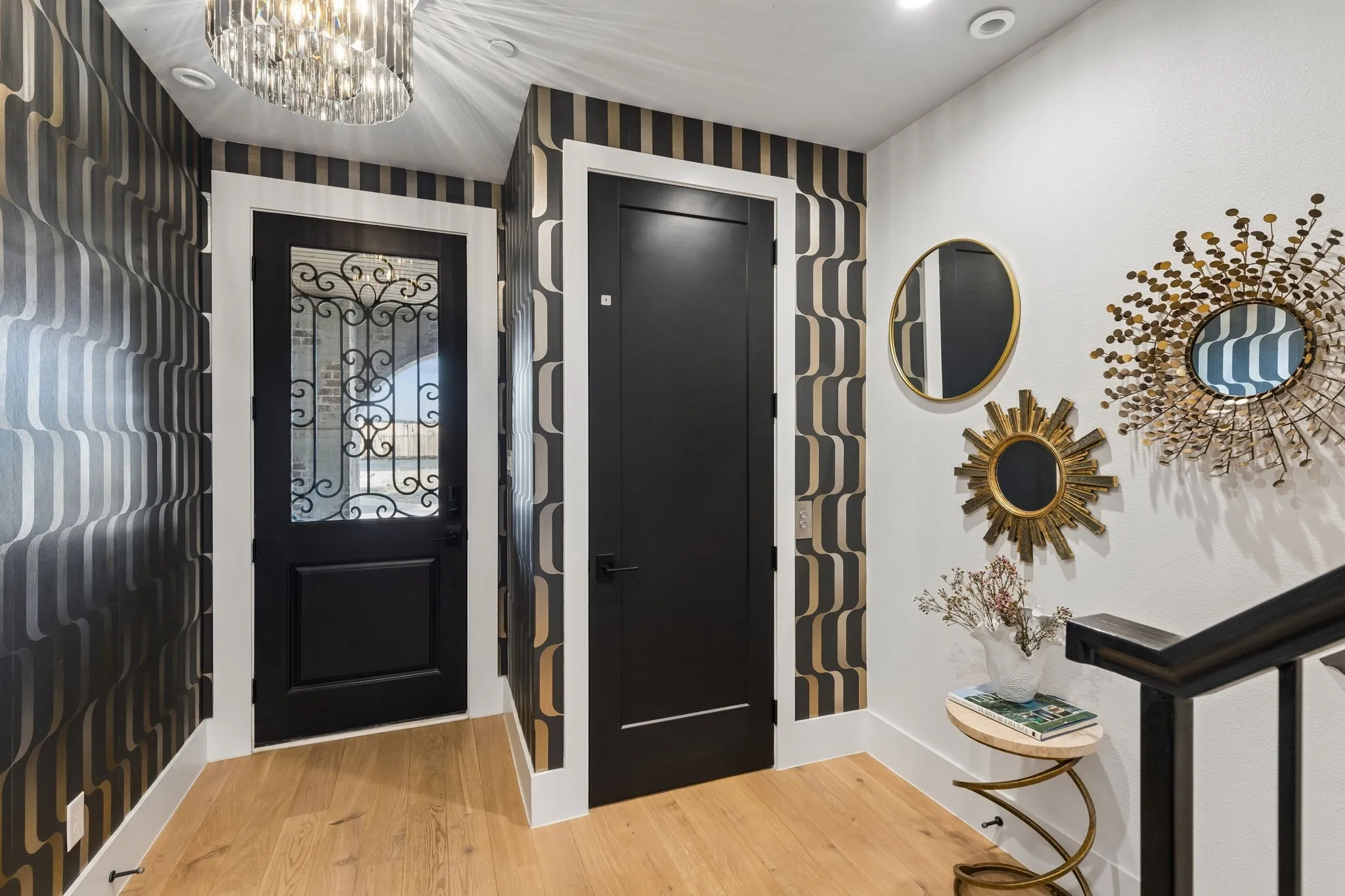 Gorgeous foyer with chandelier, wallpaper and elevator entrance.