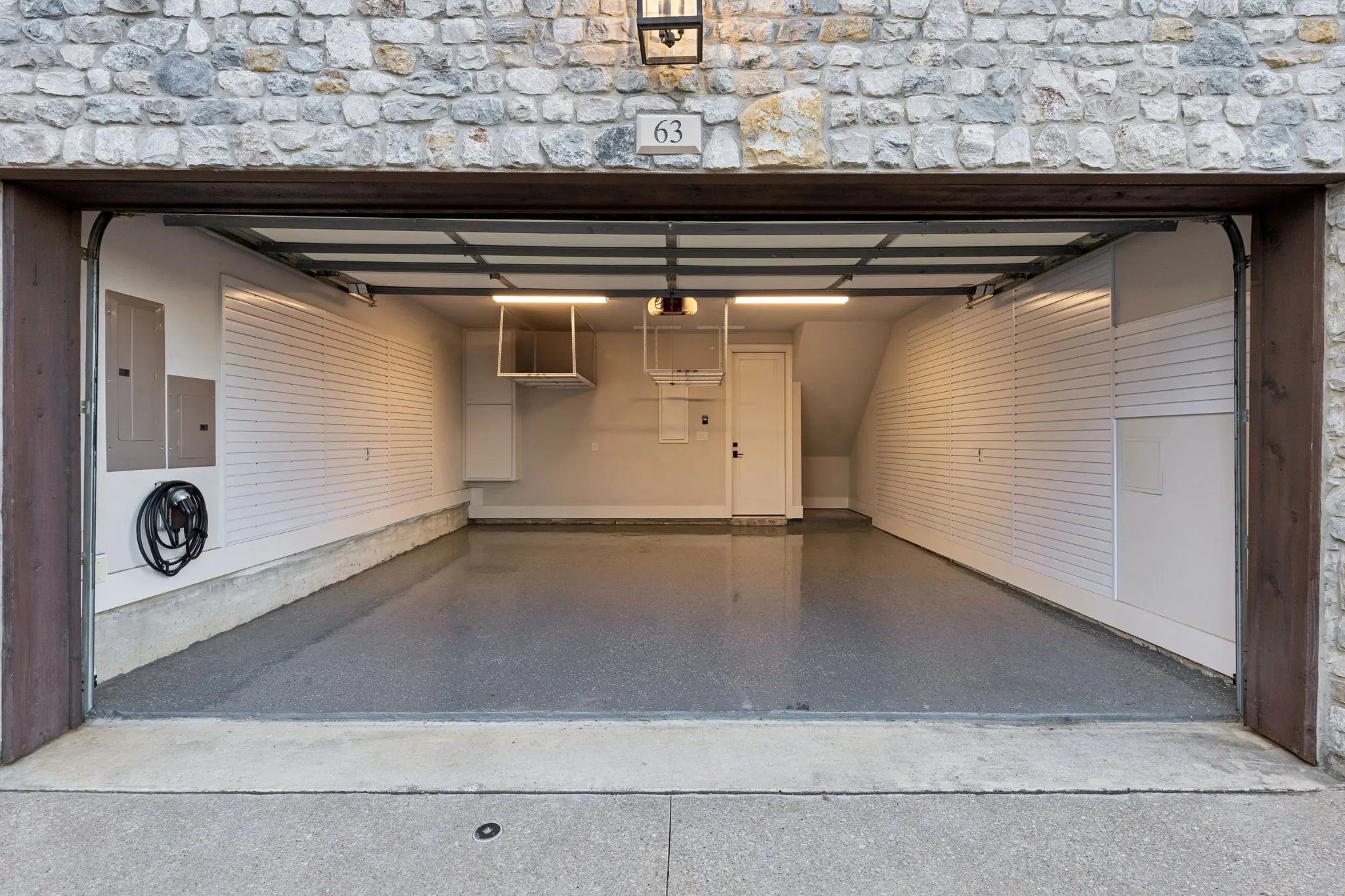 Garage with slat walls and overhead storage, epoxy flooring,level 2 EV charger
