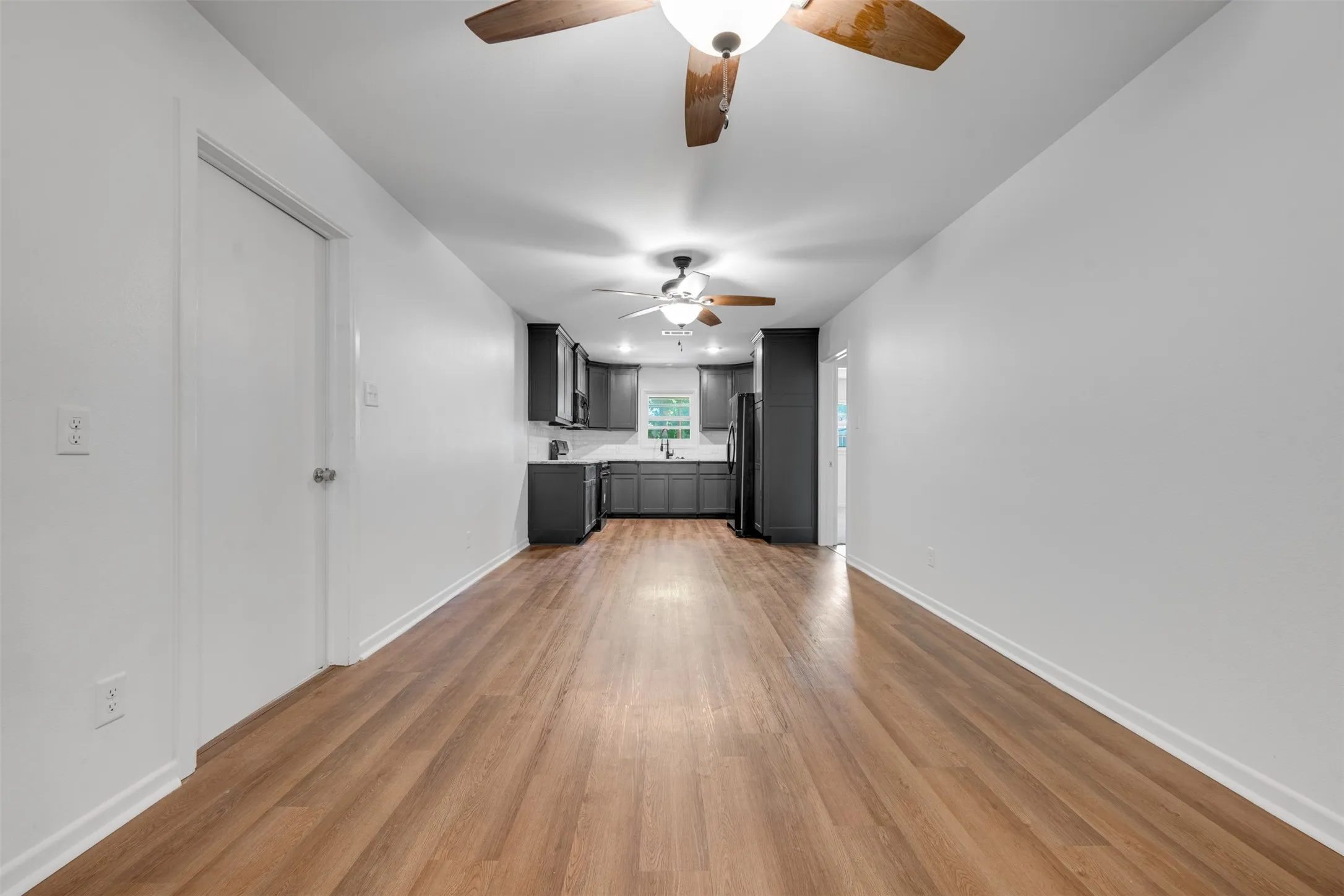 Open-concept living area with wood-finish flooring extending into the kitchen