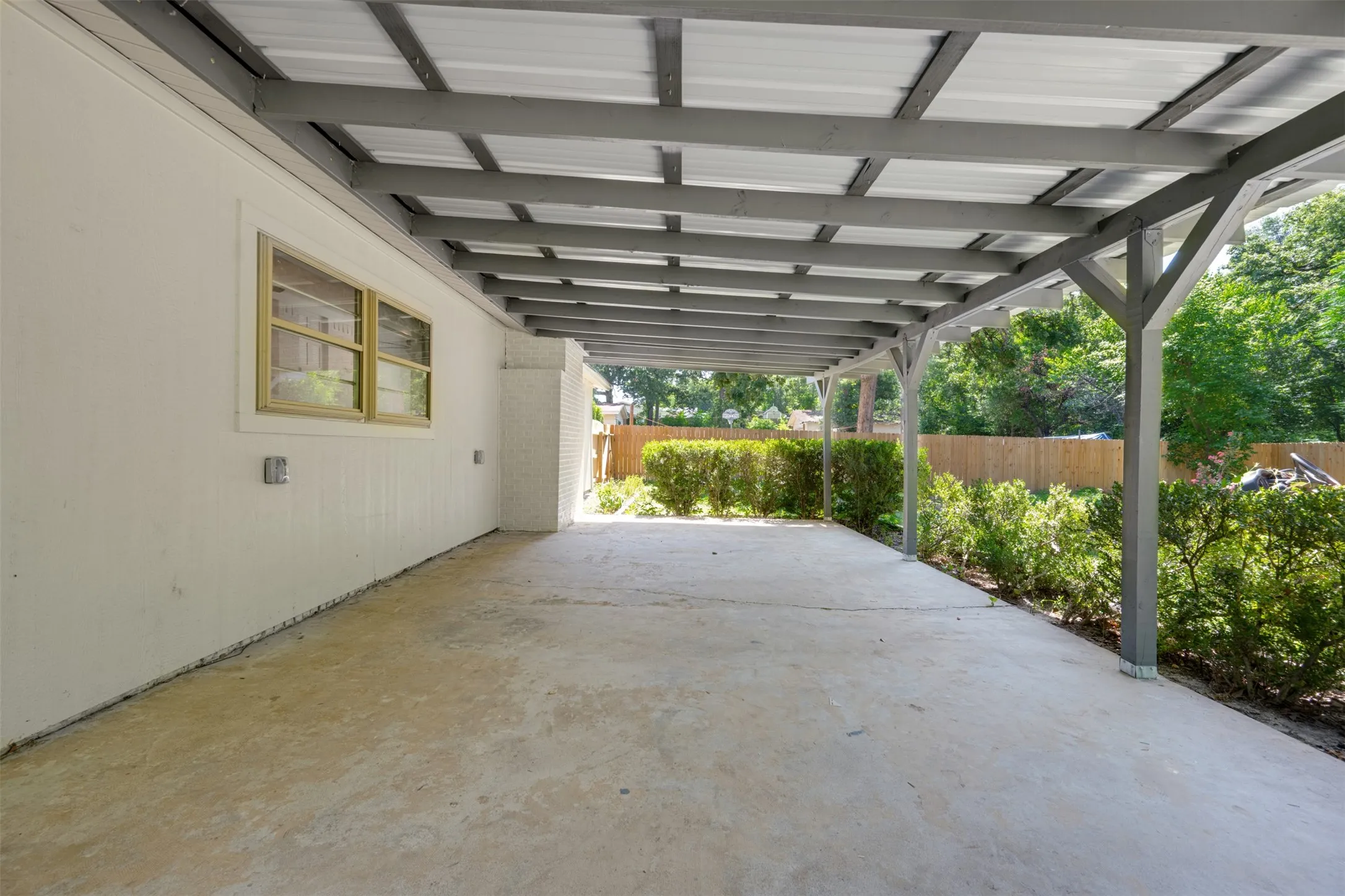 Covered patio with a concrete slab and a white painted exterior wall