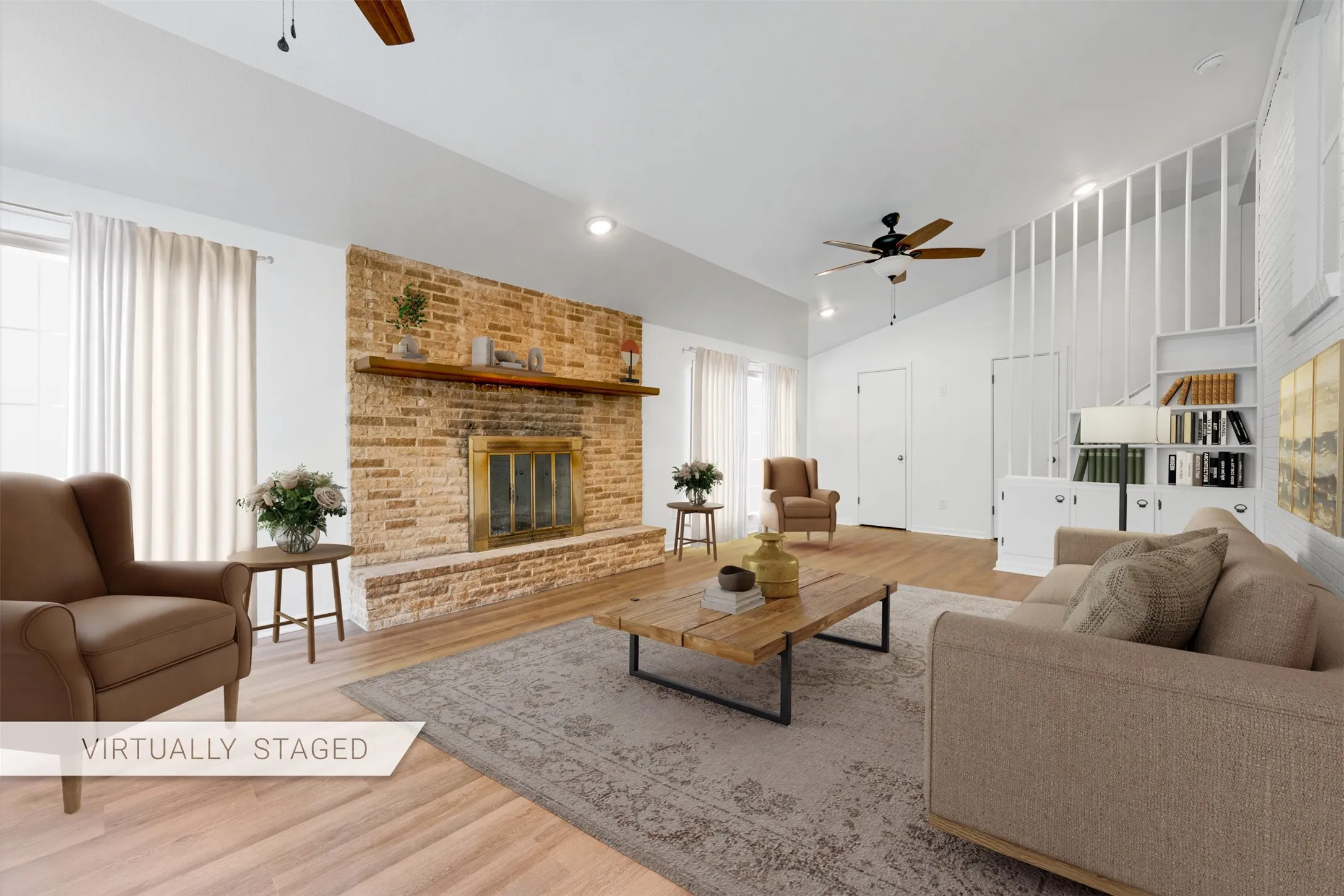 Spacious living area featuring a prominent brick fireplace with a wood mantel, vaulted ceilings, and light wood-finish flooring