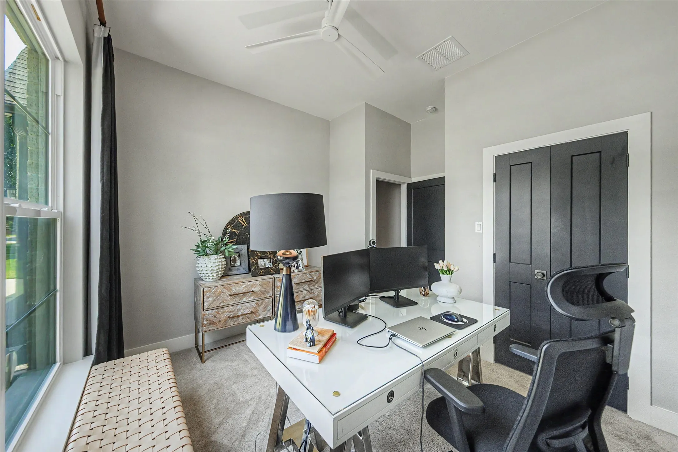 Home office featuring a double-hung window, light gray wall paint, and gray carpeting
