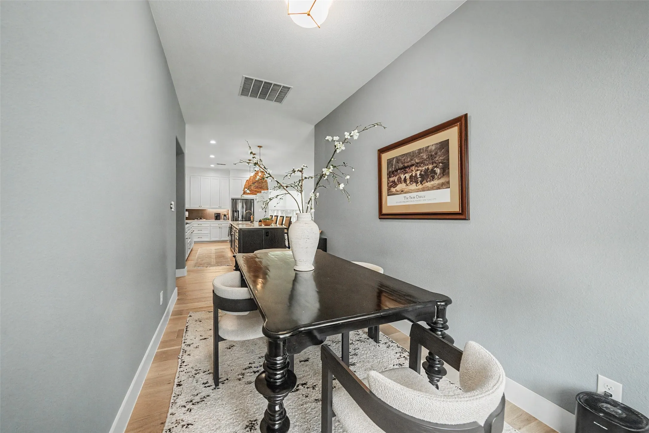 Light wood-finish flooring extends through this interior space, featuring light gray walls and white baseboards