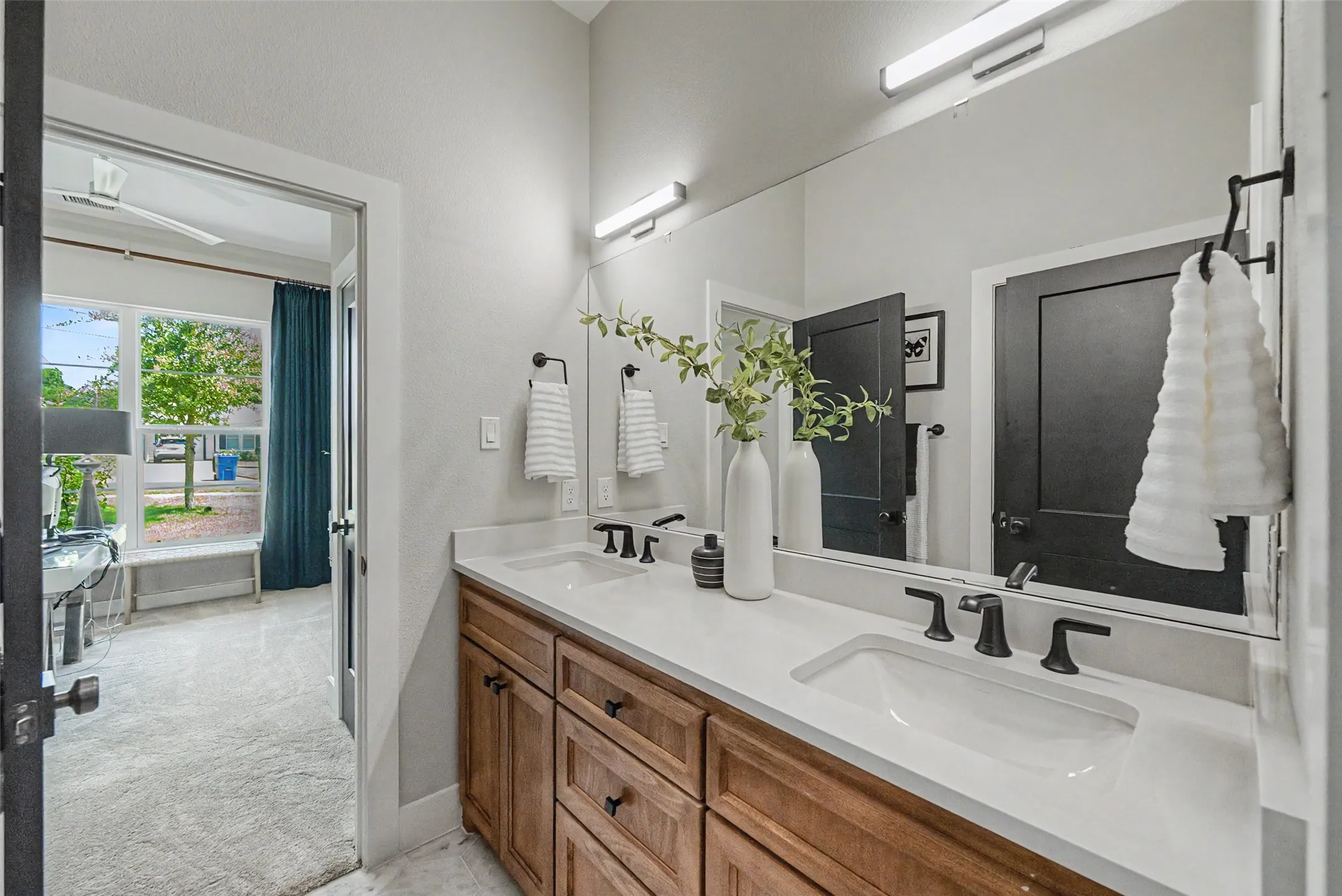 Double vanity featuring rectangular undermount sinks, matte black faucets, and a full-width mirror