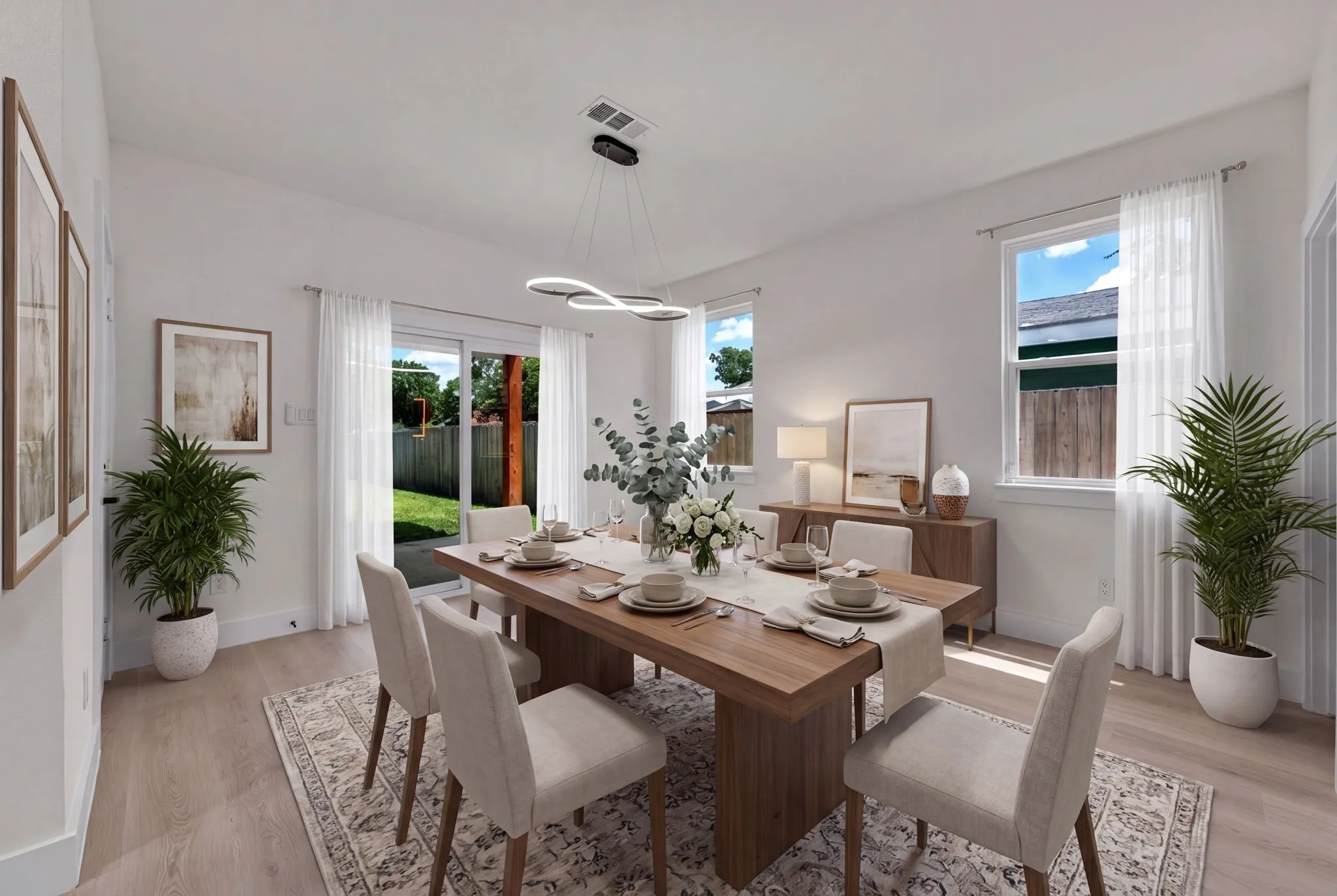 Bright dining area featuring light-toned wood-finish flooring and a contemporary linear pendant light fixture