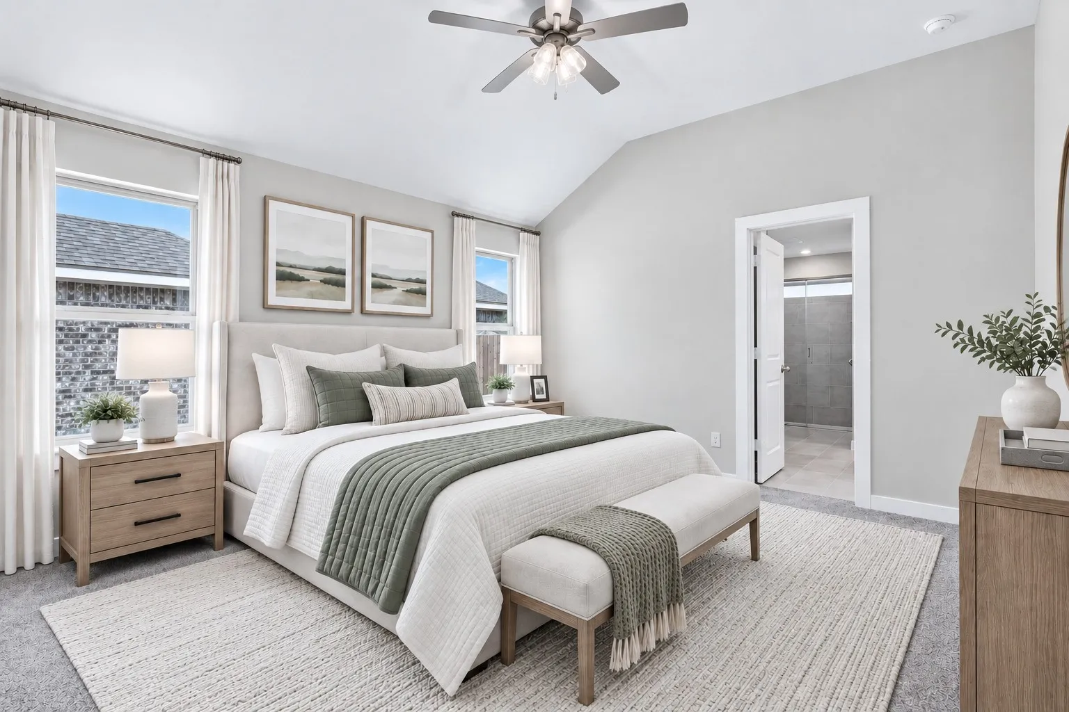 Vaulted ceiling with an attached ceiling fan, large windows with white trim, and light gray wall paint