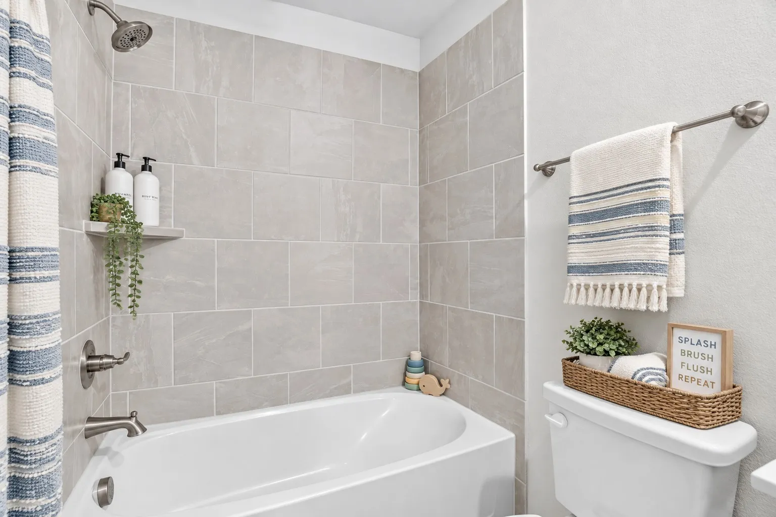 Tub and shower combination featuring floor-to-ceiling tile surround and brushed nickel fixtures