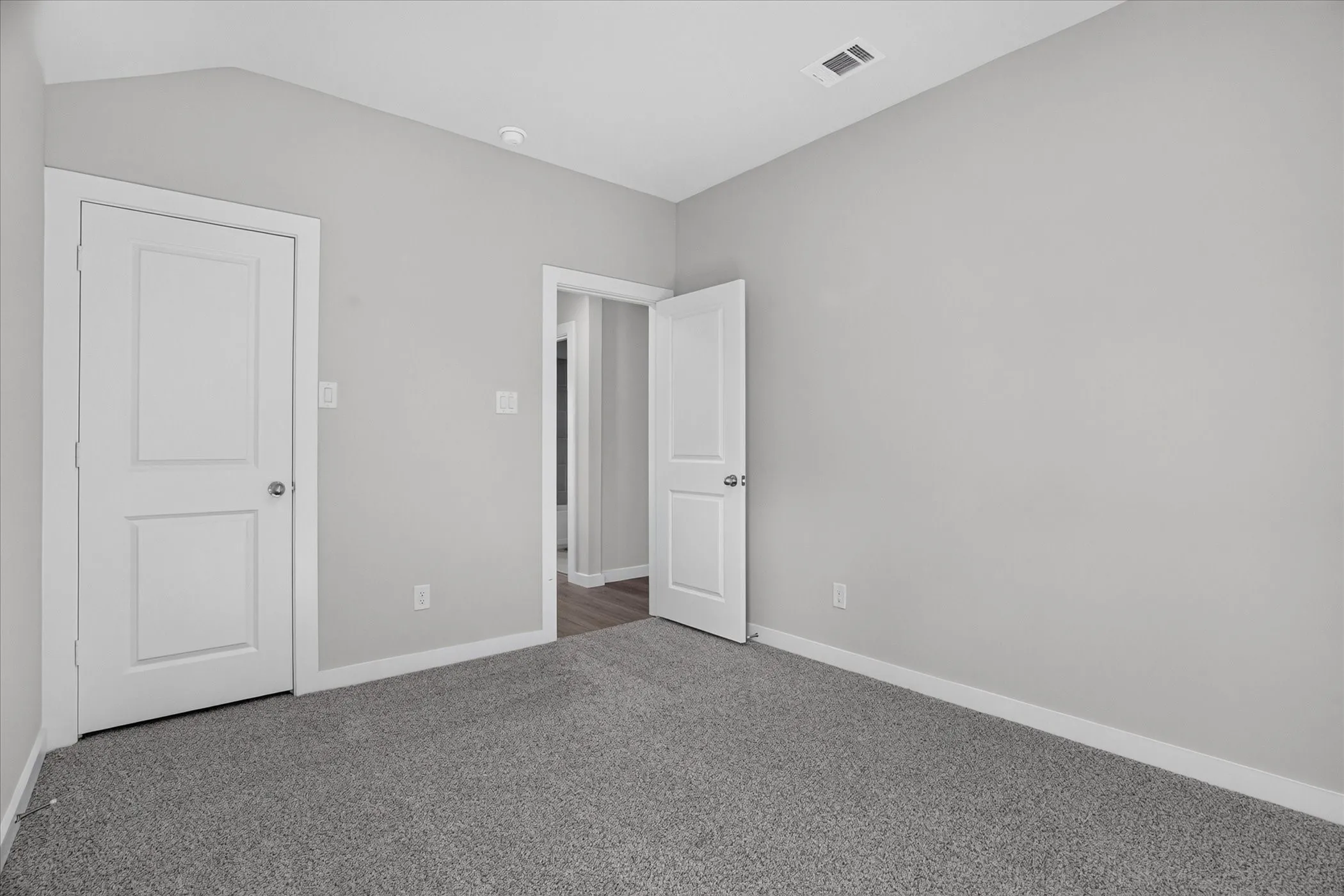 Room featuring light gray walls, gray carpeting, and white trim