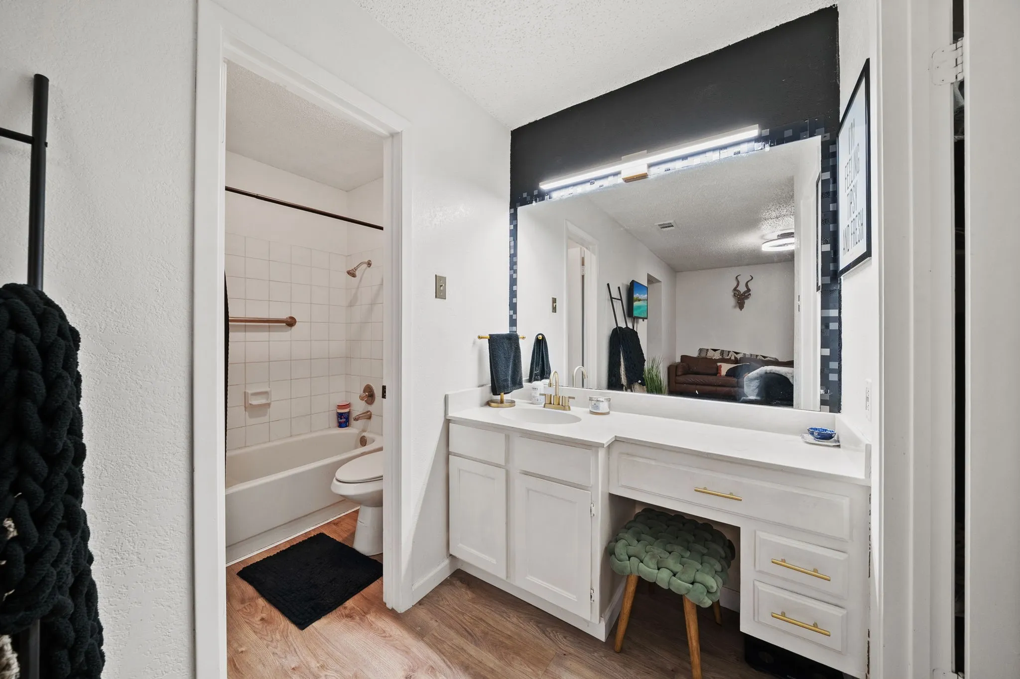 Bathroom featuring wood-finish flooring and a white vanity with an integrated countertop
