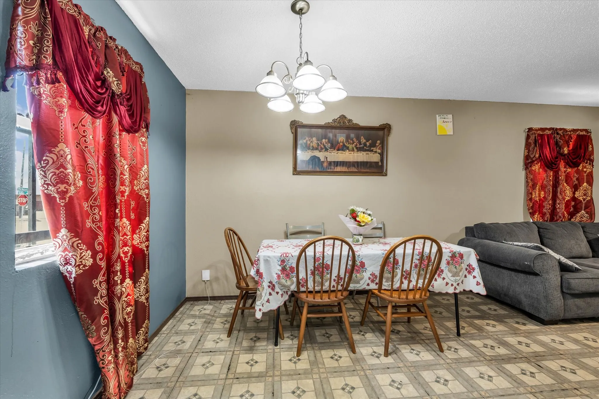 Dining area featuring patterned floor tiles, a window with a sill, and a ceiling-mounted light fixture