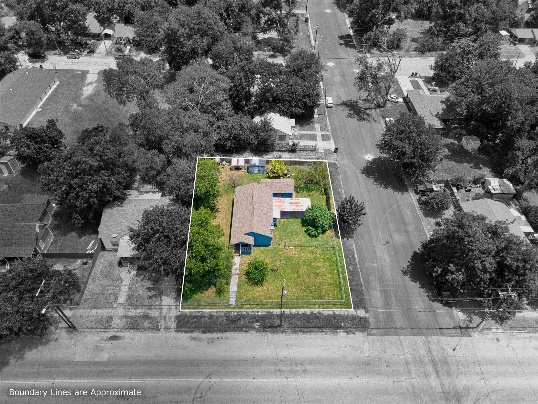 Aerial perspective showcasing a property with a blue exterior and a brown shingle roof