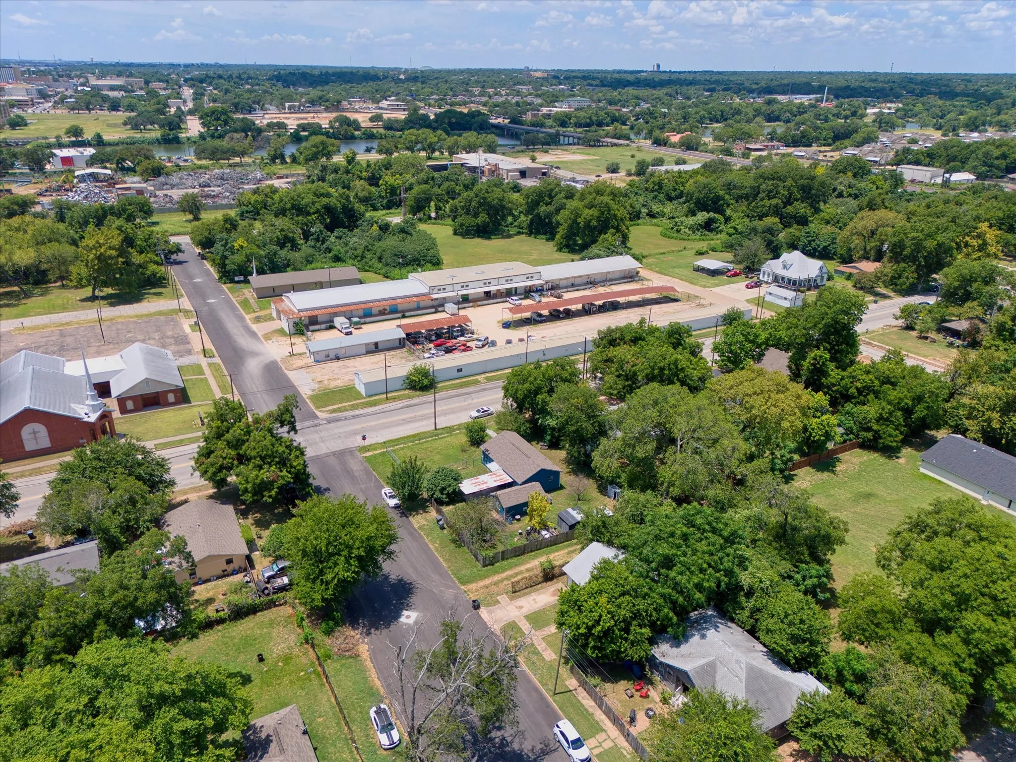 Aerial perspective of a mixed-use neighborhood featuring residential properties and commercial buildings