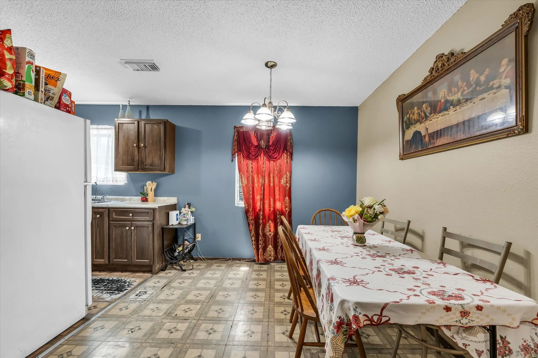 Combined kitchen and dining area featuring wood-finish cabinetry, a white countertop, and patterned flooring