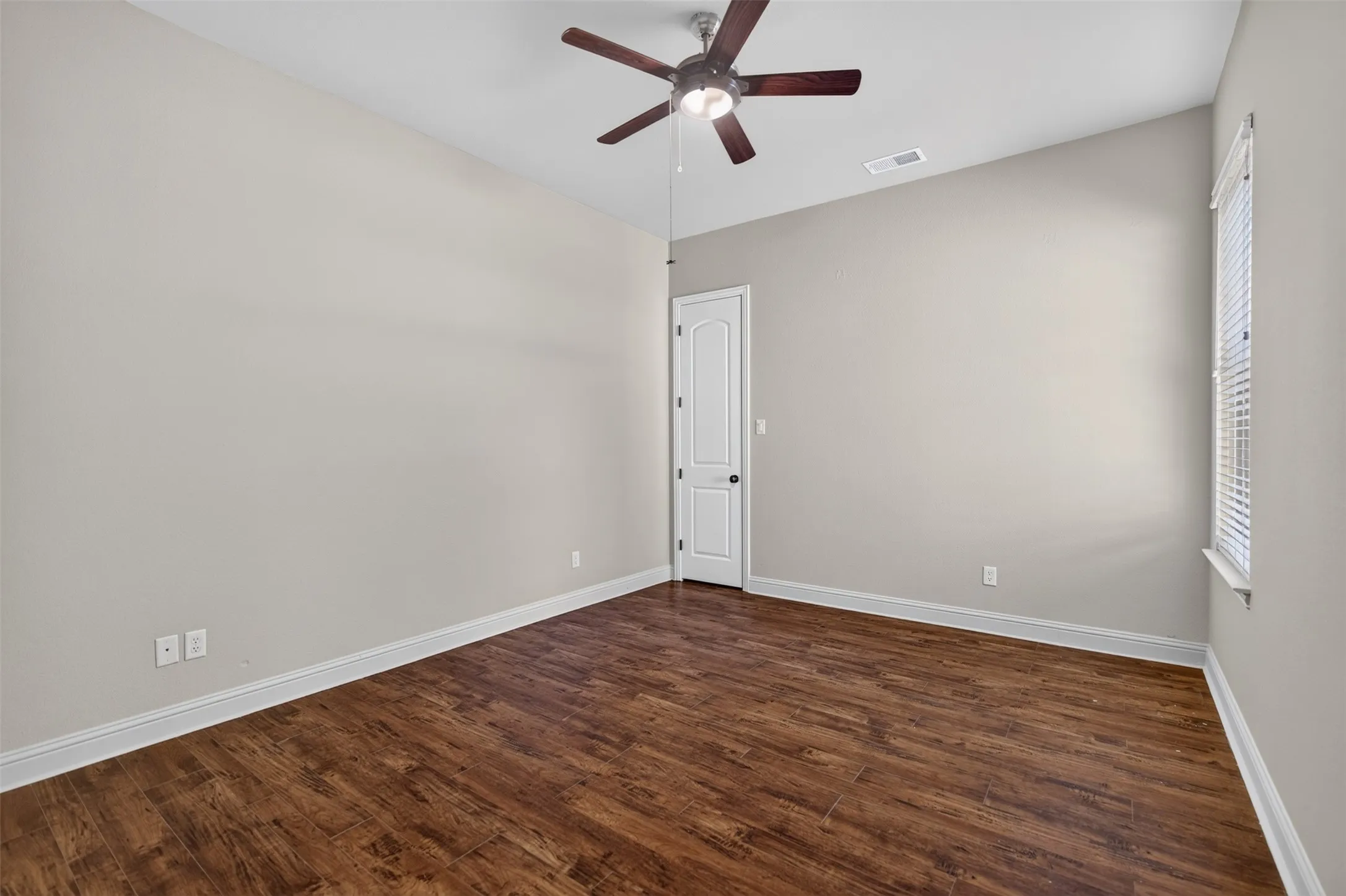 Vaulted ceiling with a ceiling fan, wood-finish flooring, white trim, and a window with blinds