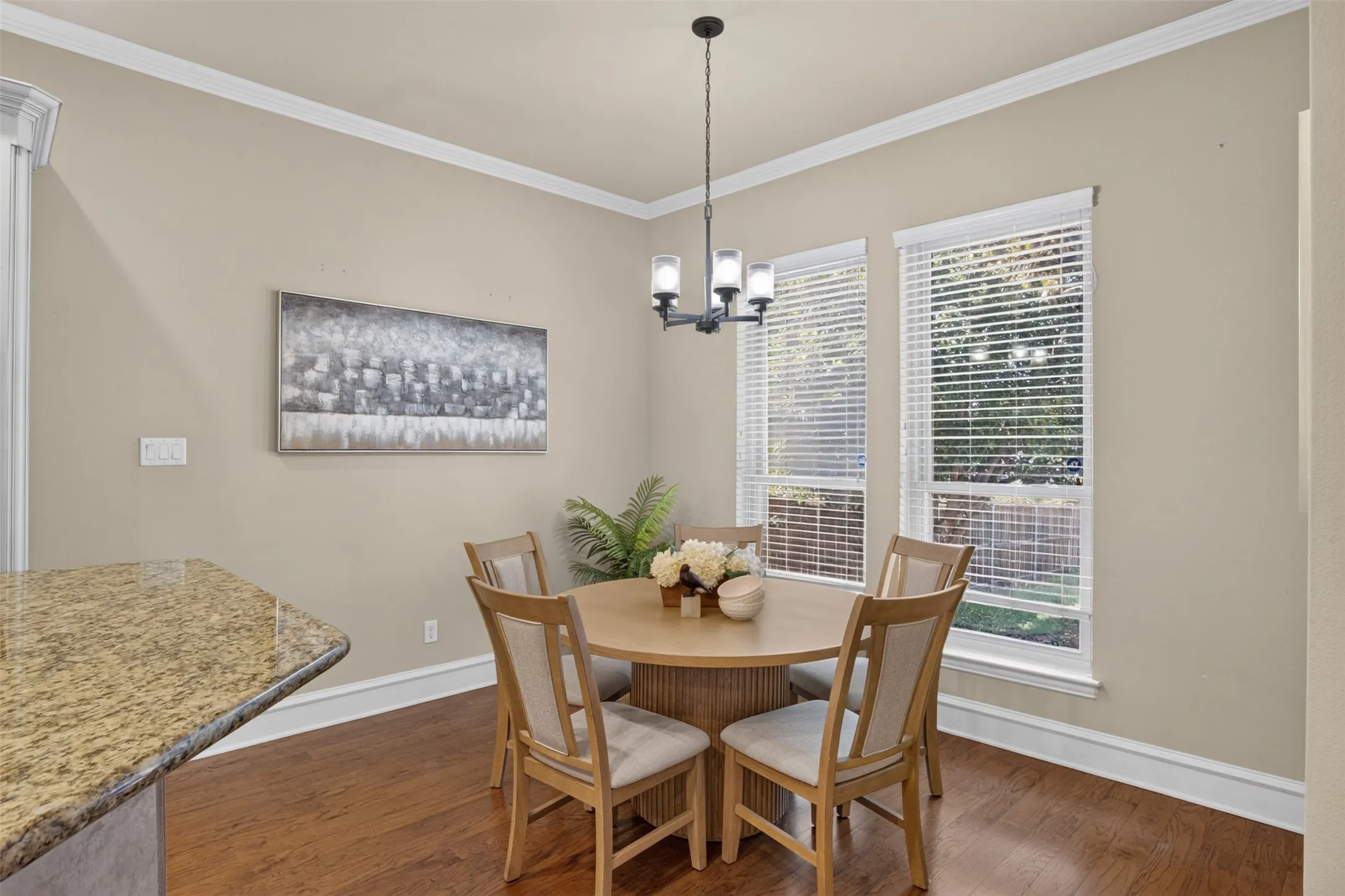 Hardwood flooring, crown molding, double pane windows, granite countertop, and a contemporary chandelier