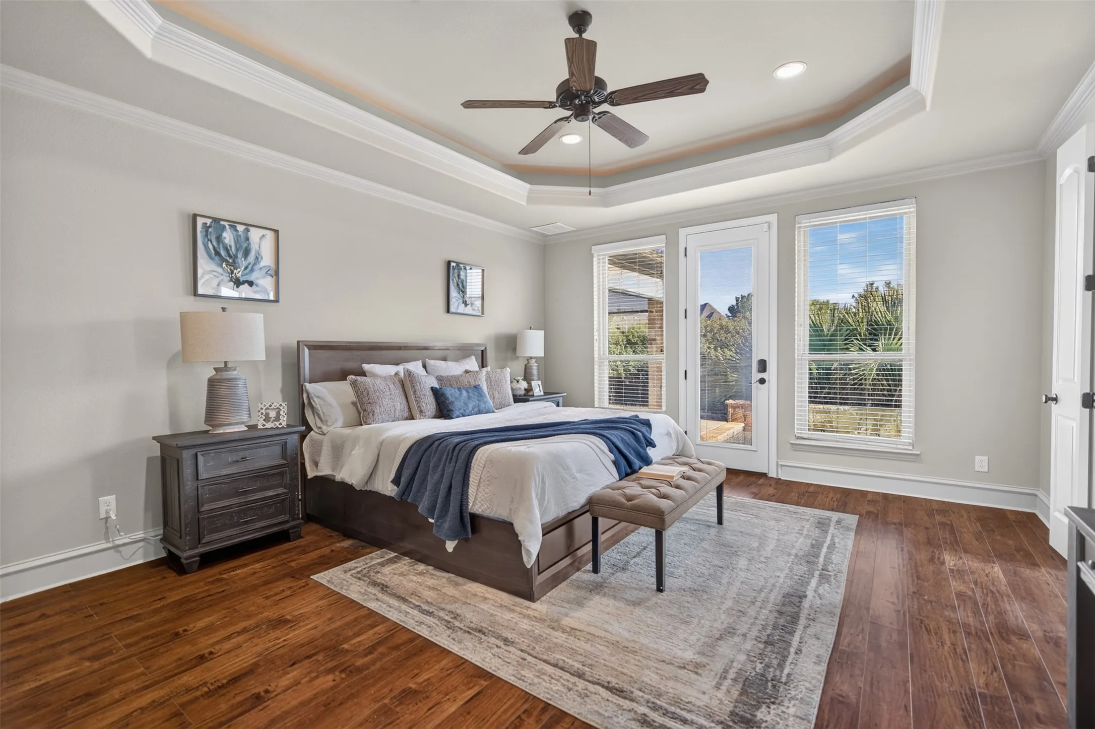 Tray ceiling with crown molding, wood-finish flooring, ceiling fan, recessed lighting, and direct patio access to the pool