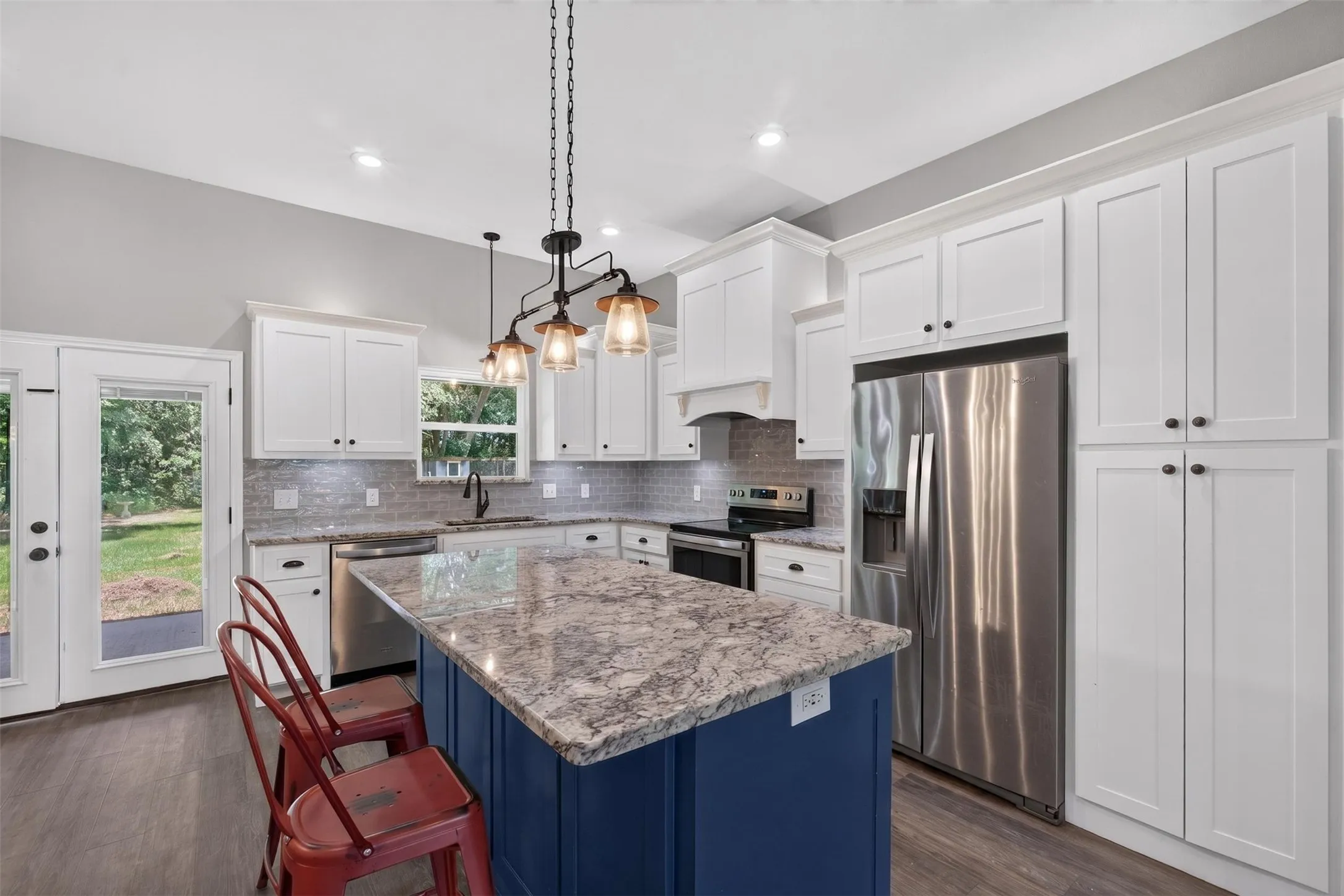Kitchen featuring a central island with a contrasting blue base and a light-toned patterned countertop