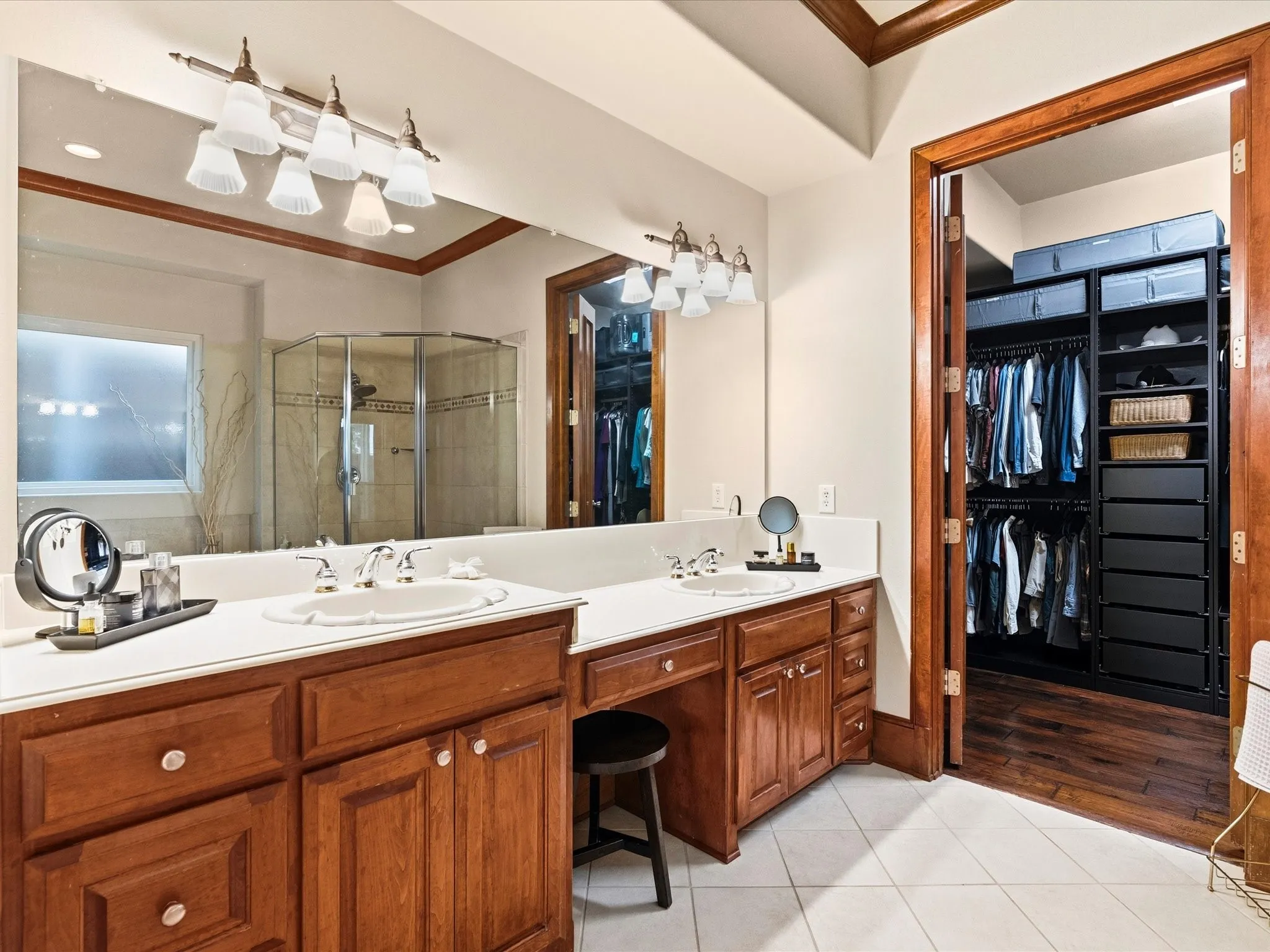 Dual vanities with white countertops, wood-finish cabinetry, and chrome fixtures